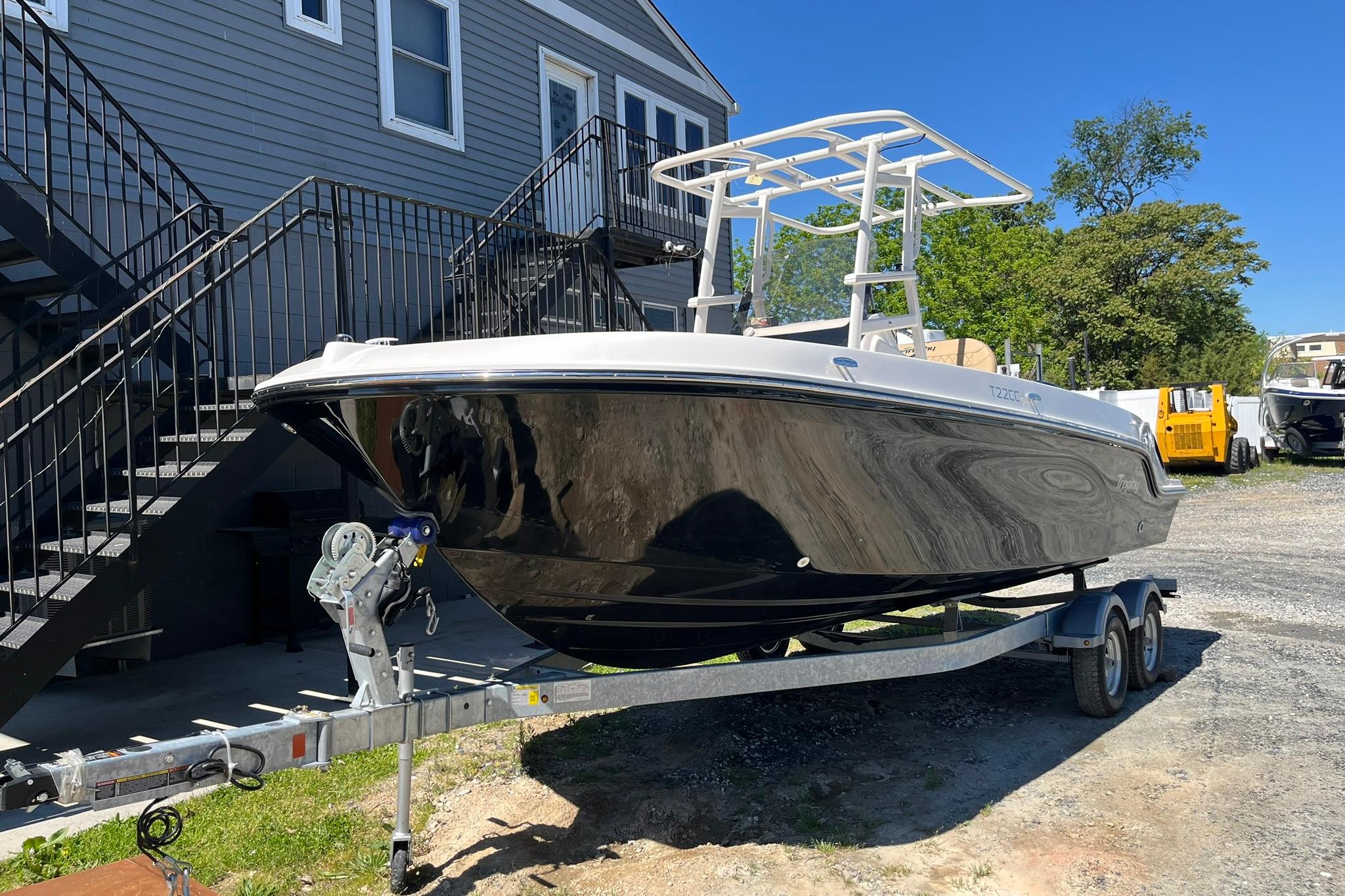 2026 Bayliner Trophy T22CC boat on trailer, parked outdoors near a building.