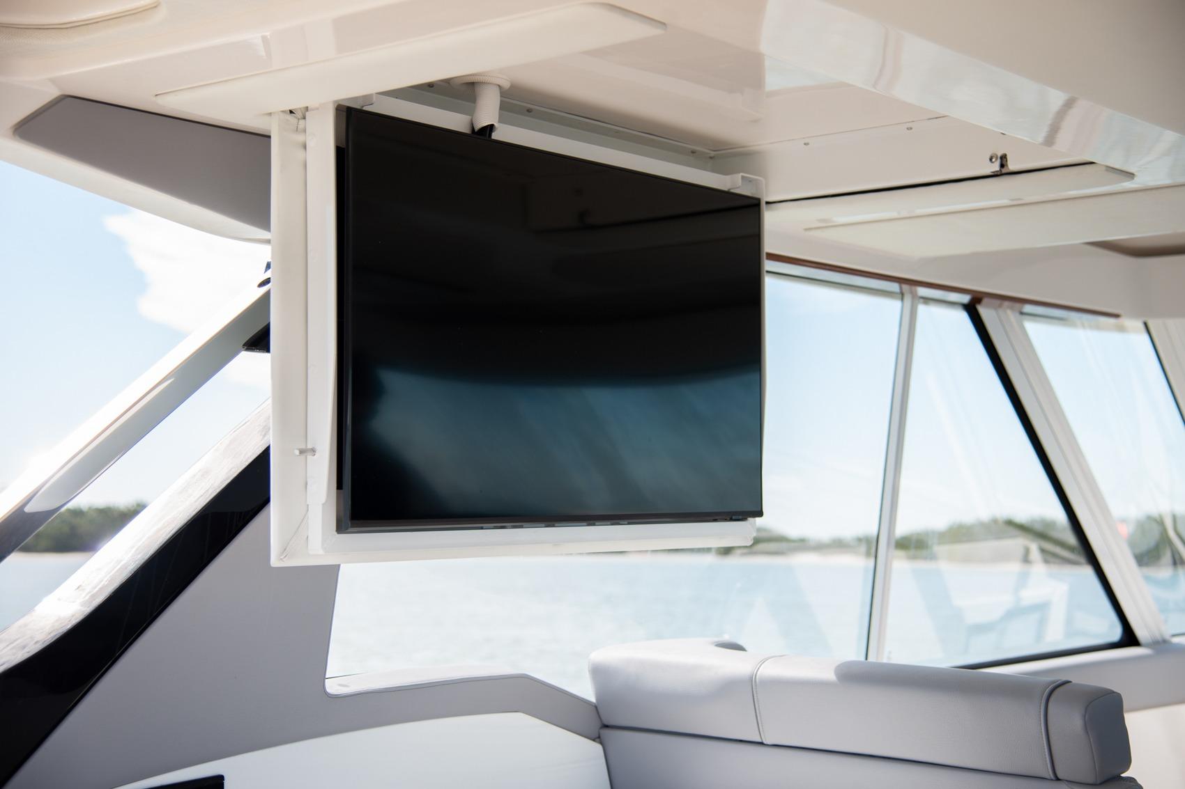 Flat-screen TV on 2026 Regal LX43 yacht interior, with panoramic windows and modern design.