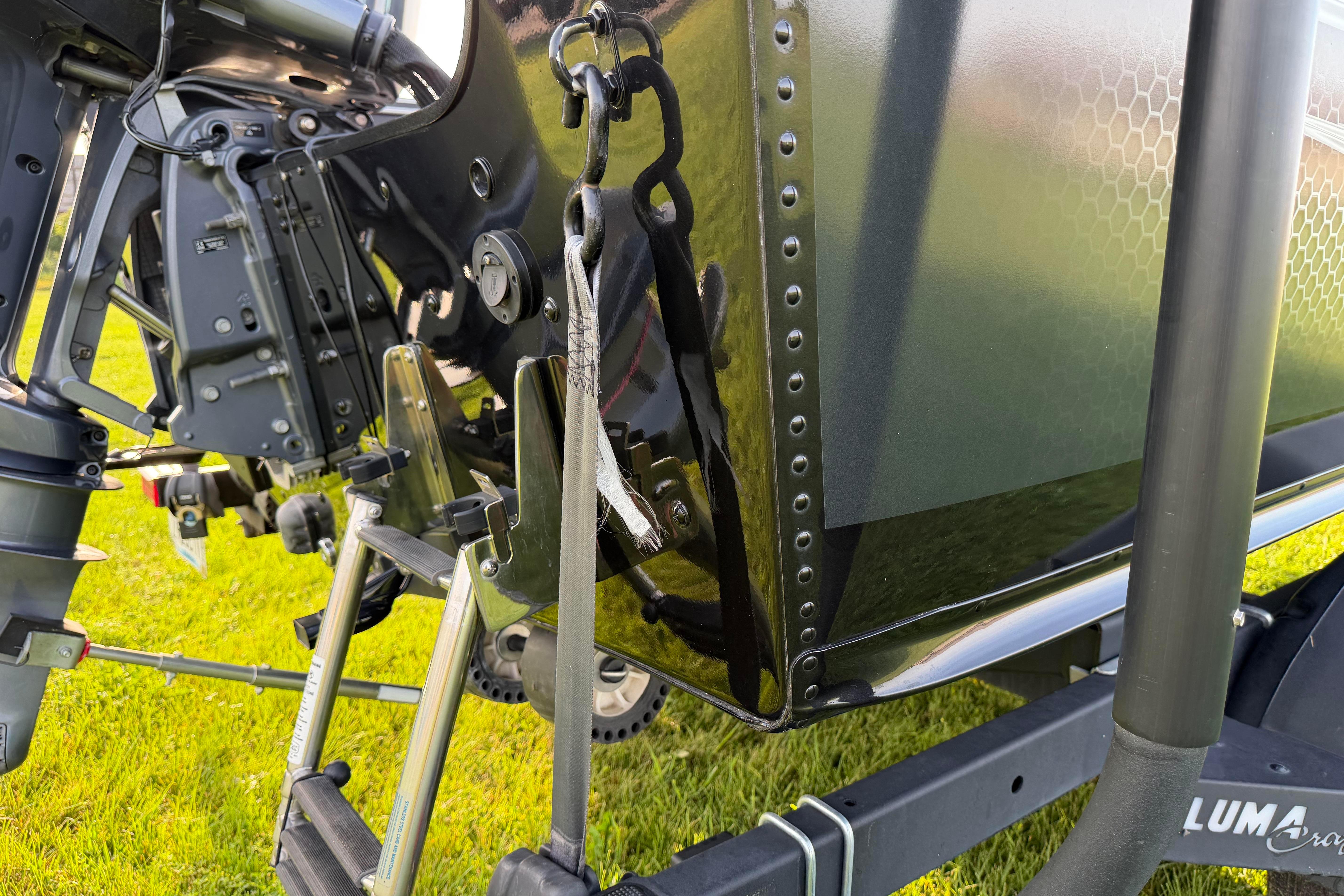 2019 Alumacraft Trophy 205 boat transom with motor and ladder on grassy surface.