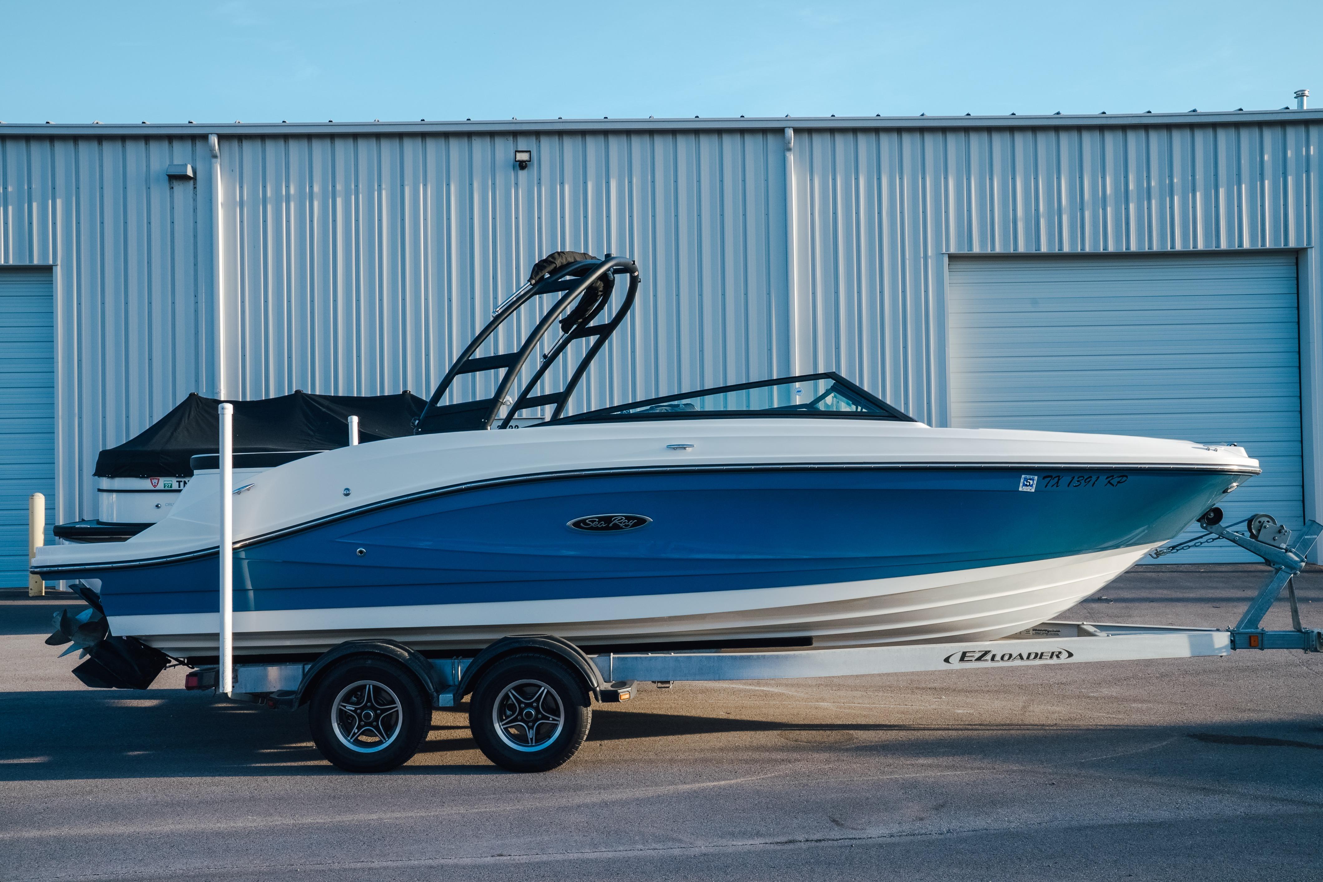 2023 Sea Ray SPX 230 boat on trailer, parked outside a warehouse.