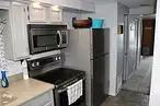 Modern kitchen interior in a 1990 Sumerset 16 x 70 houseboat, featuring stainless steel appliances.