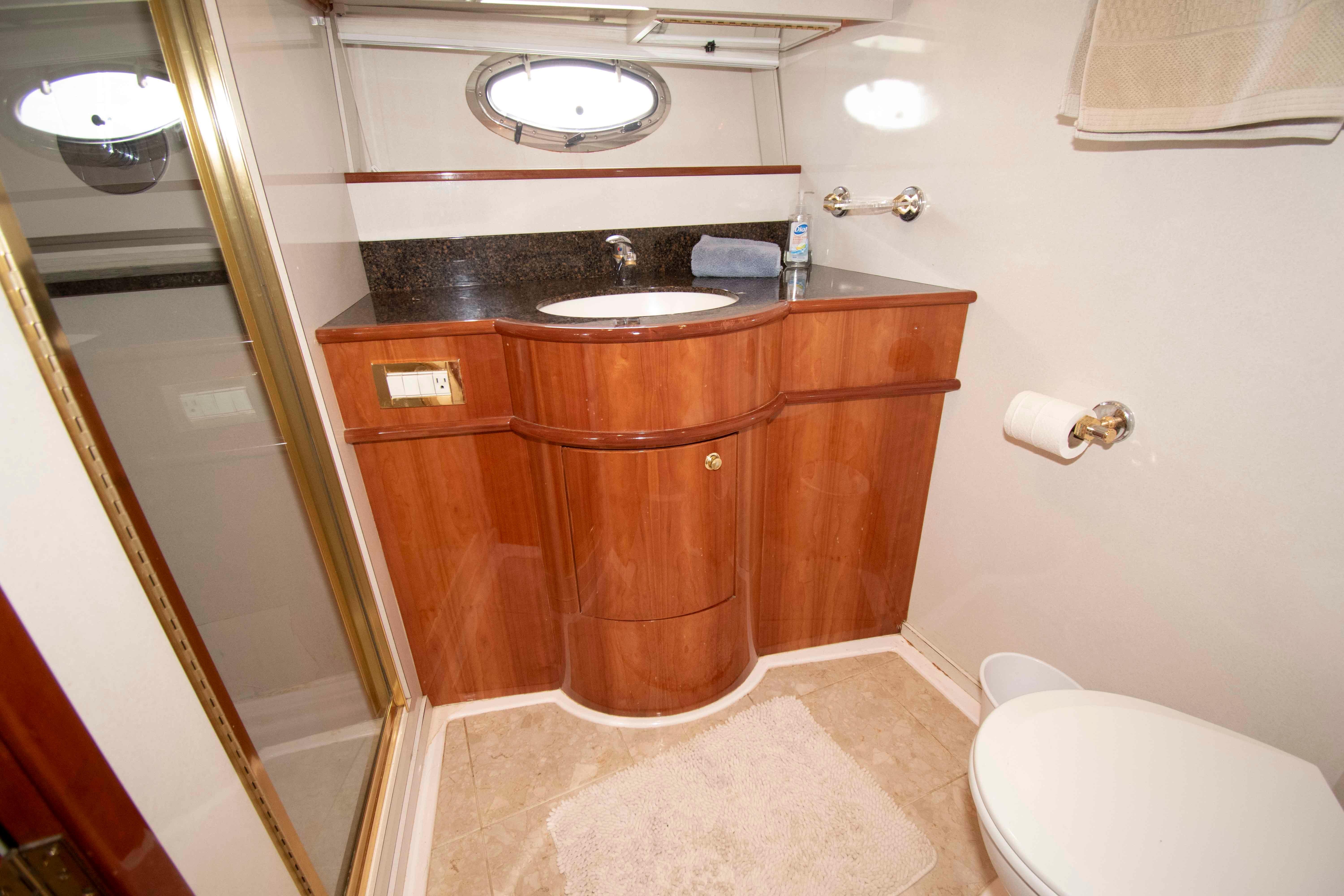 Luxurious bathroom in 2003 Neptunus 56 Flybridge yacht with wood cabinetry and modern fixtures.
