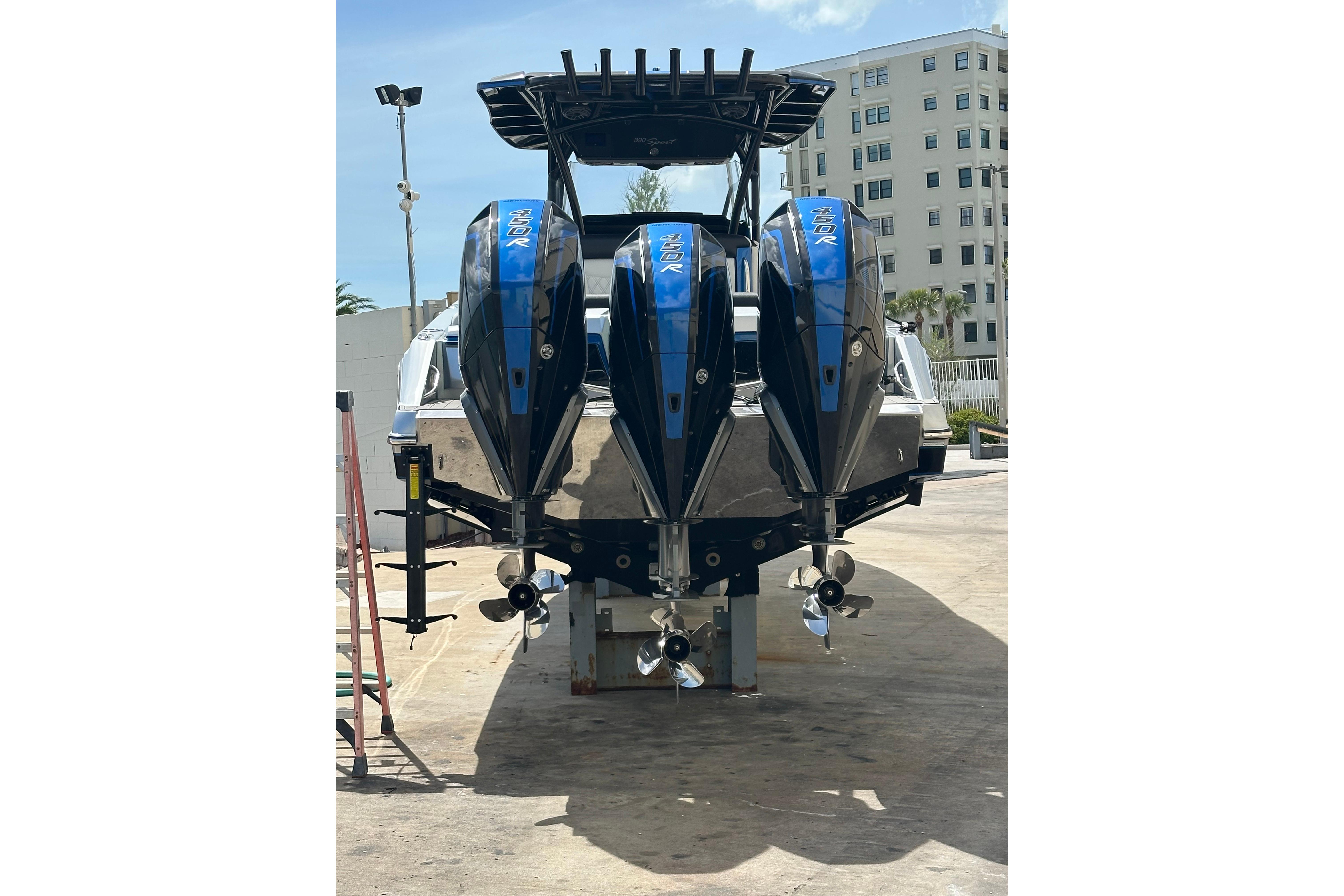 2022 Nor-Tech 390 Sport Center Console with triple outboard engines, docked outdoors.