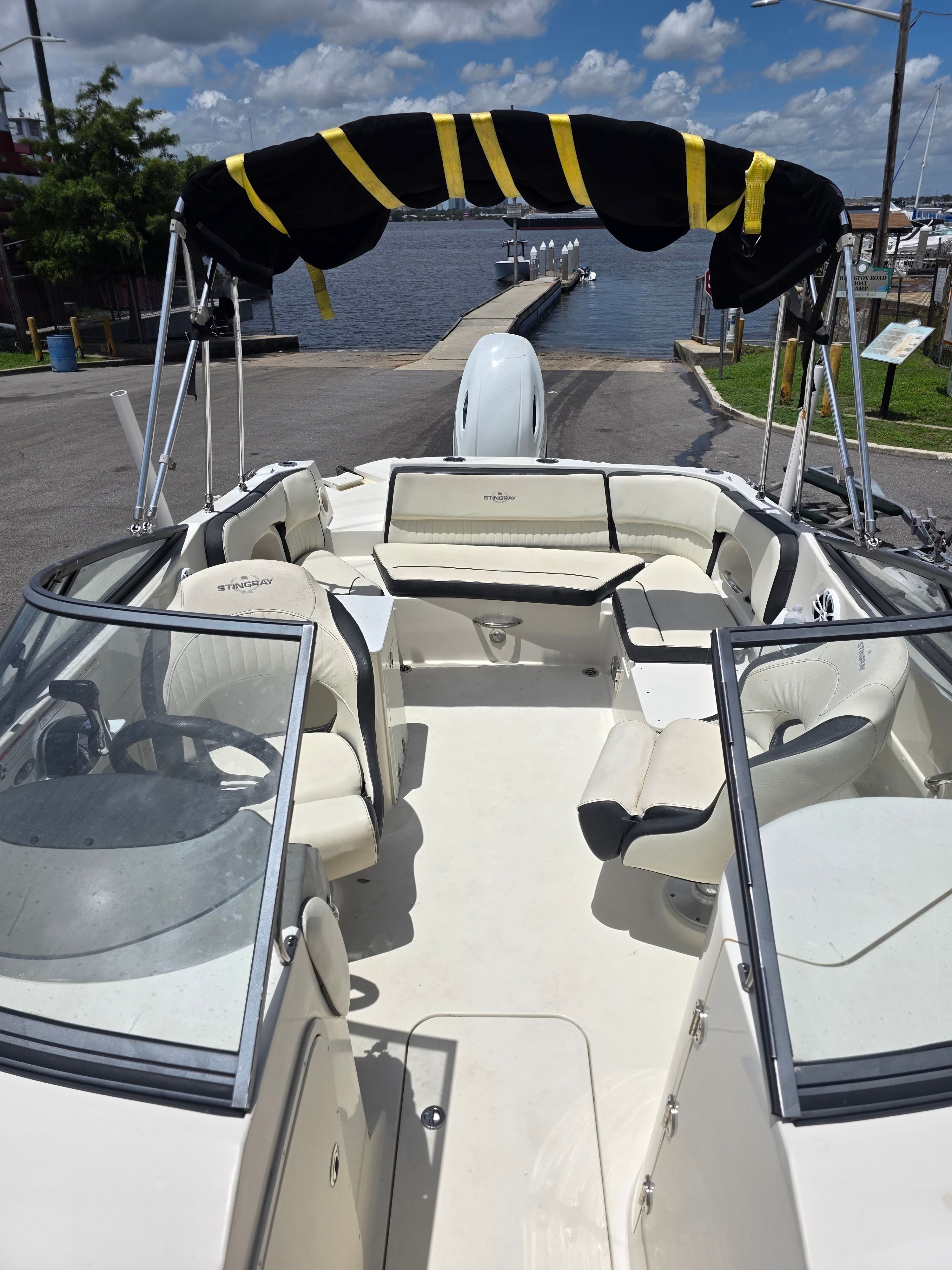 A Stingray 231 DC boat at a dock with a black sunshade.