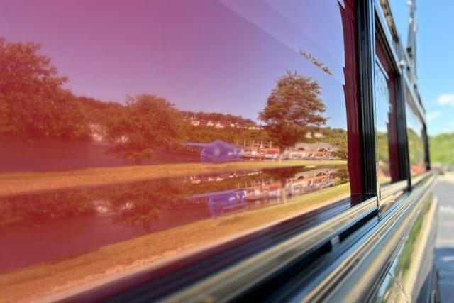 Reflection of trees and landscape on a 2025 Regency 250 DL3 vehicle.