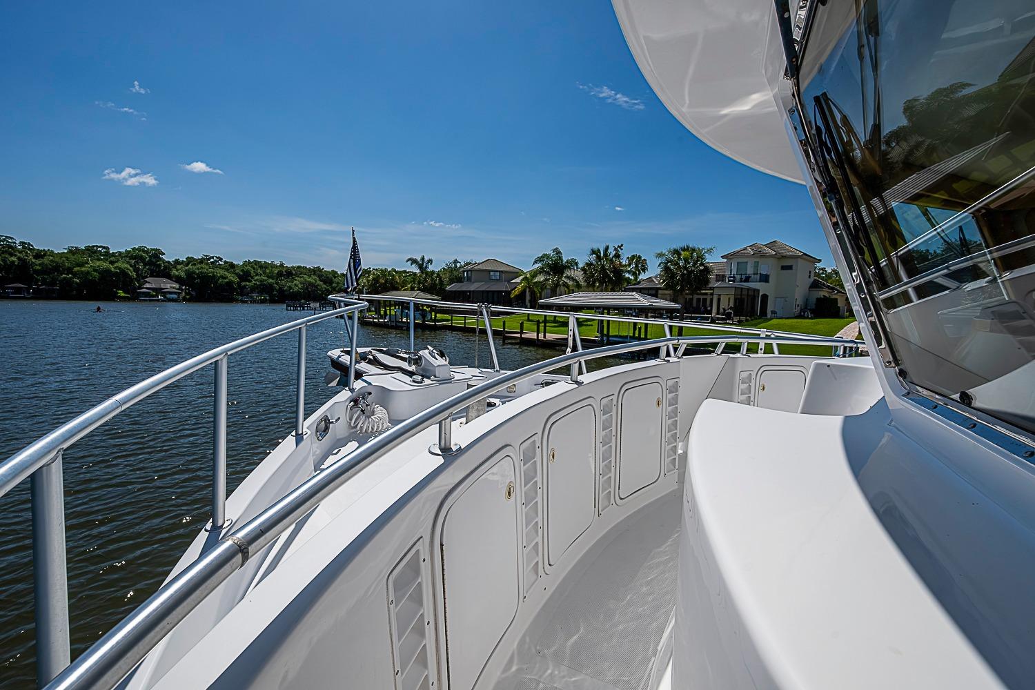2003 Magna Marine Nova Scotia 47 yacht on serene waterfront with clear blue sky.