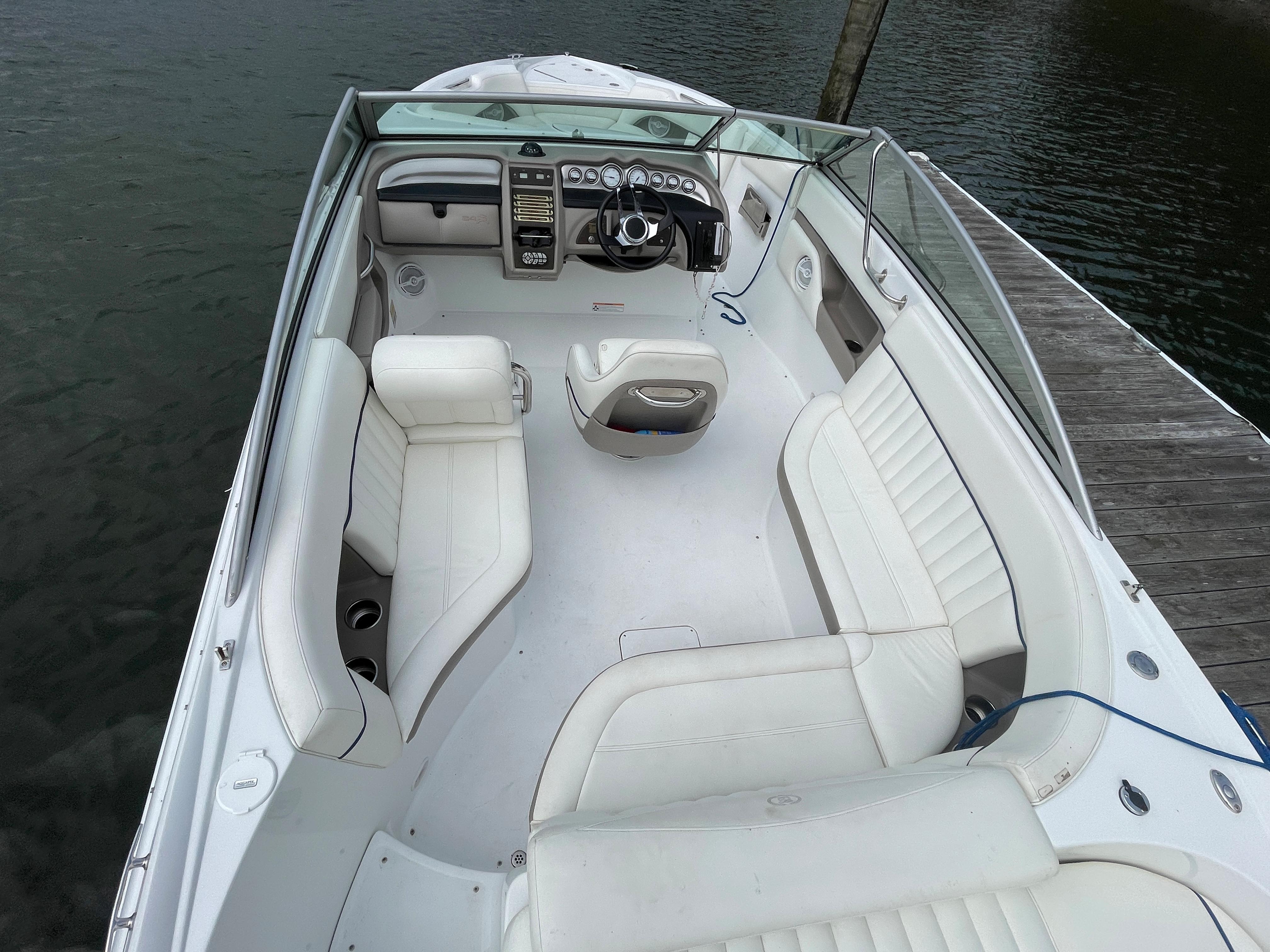 2006 Cobalt 24SX boat with white interior, docked on calm water.