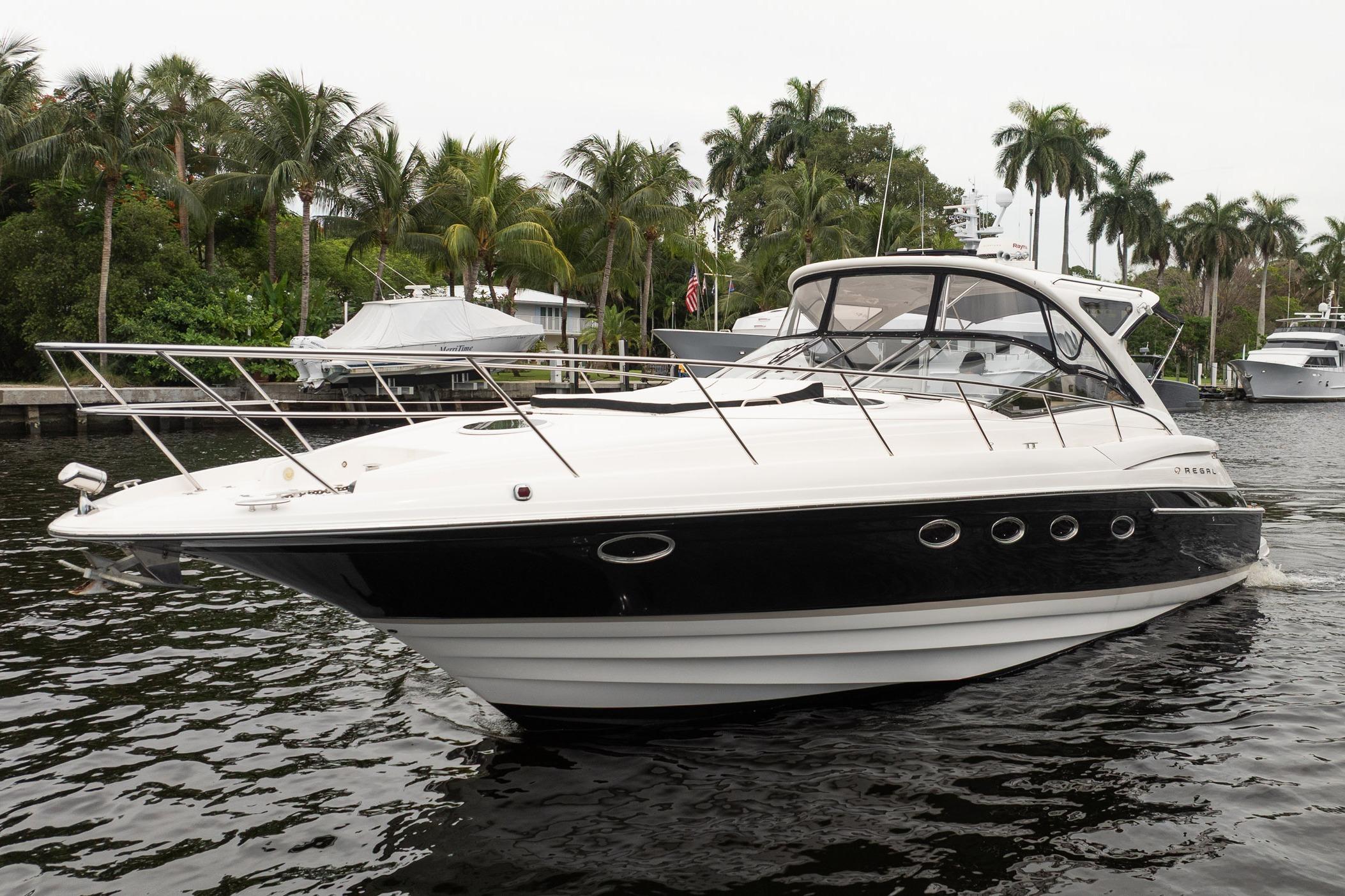 2008 Regal Commodore 4460 yacht cruising on a tropical waterway with palm trees.