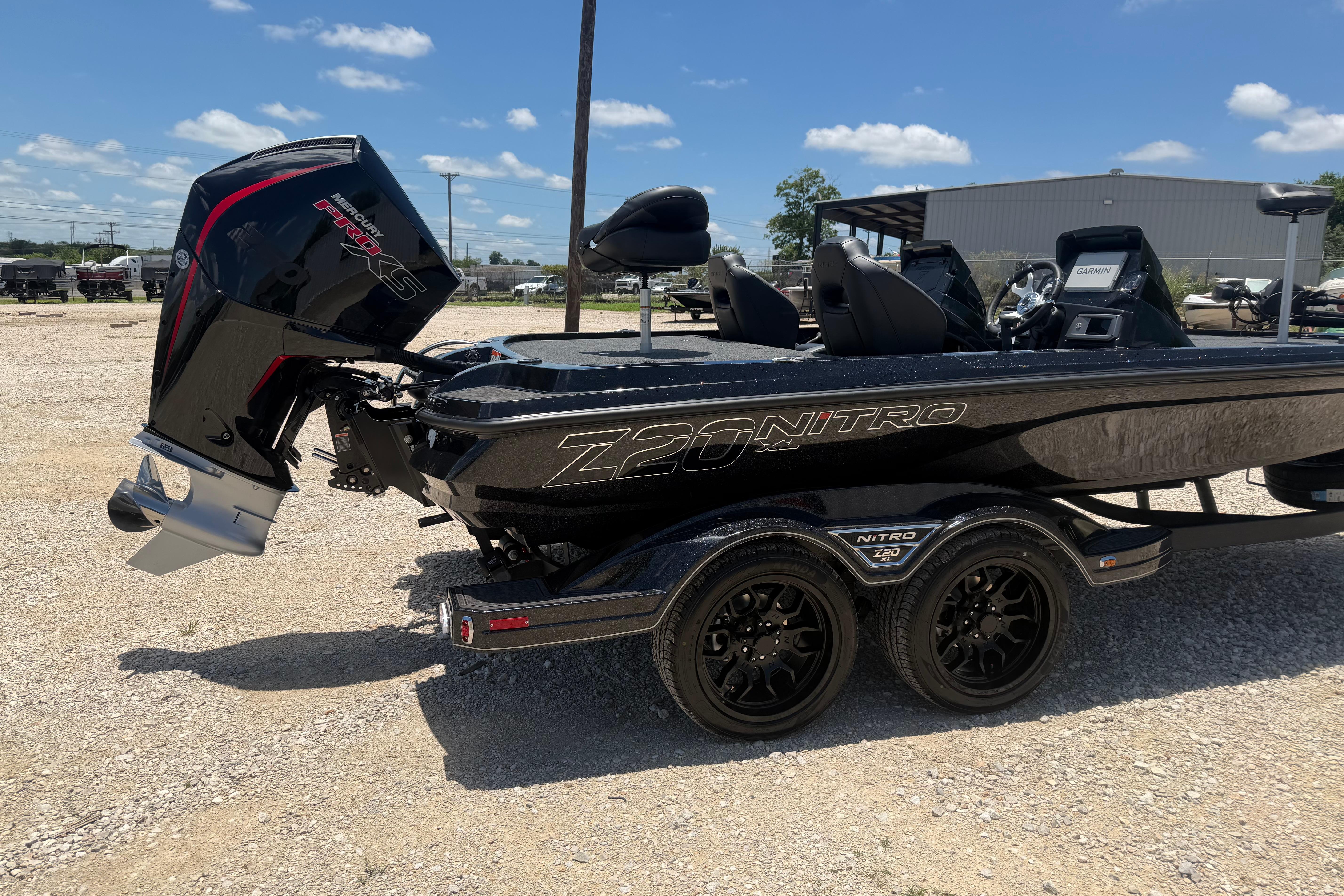 2026 Nitro Z20 XL Pro boat with Mercury engine, parked on gravel under blue sky.