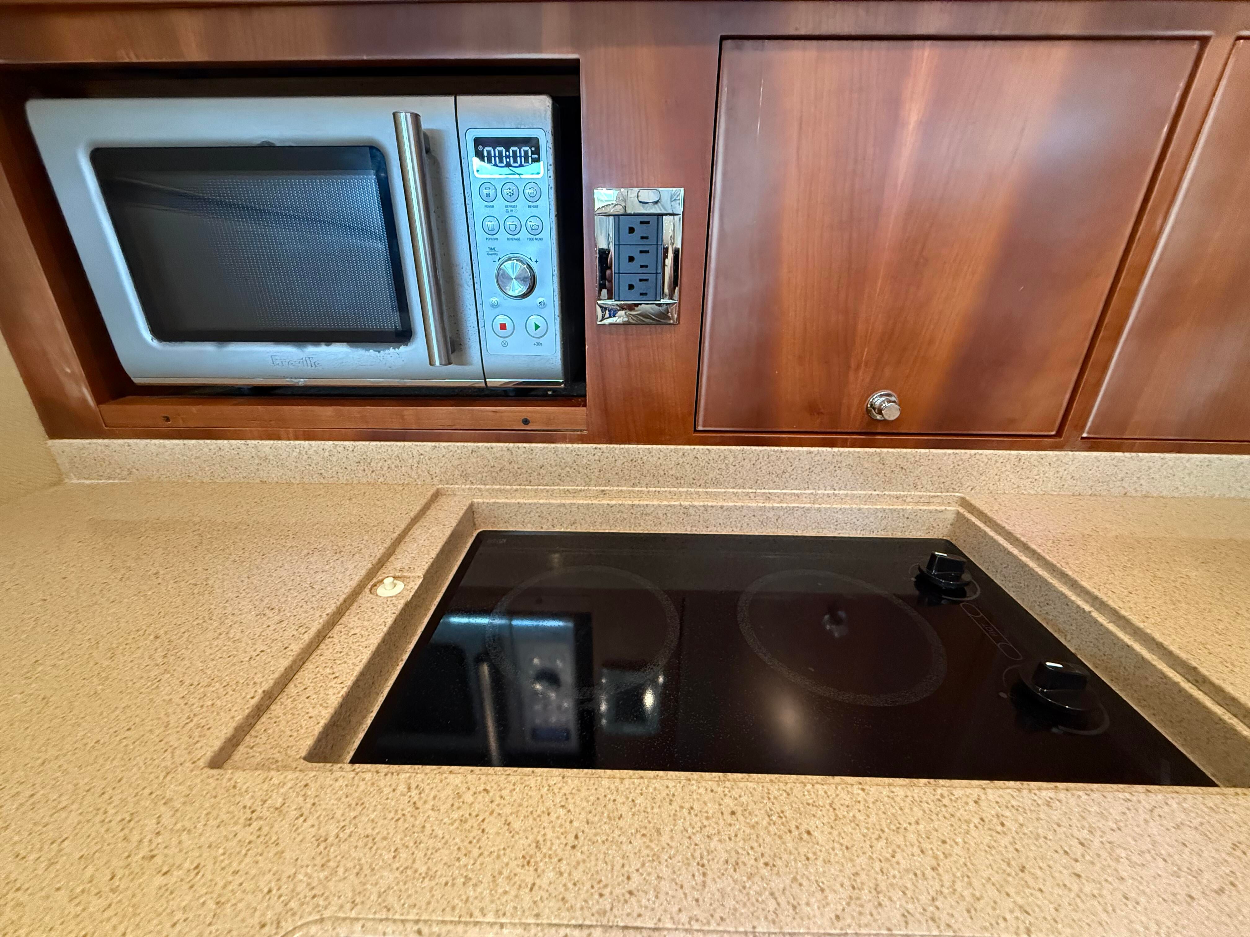 Kitchen with microwave and cooktop in a 2007 Chris-Craft Roamer 40.