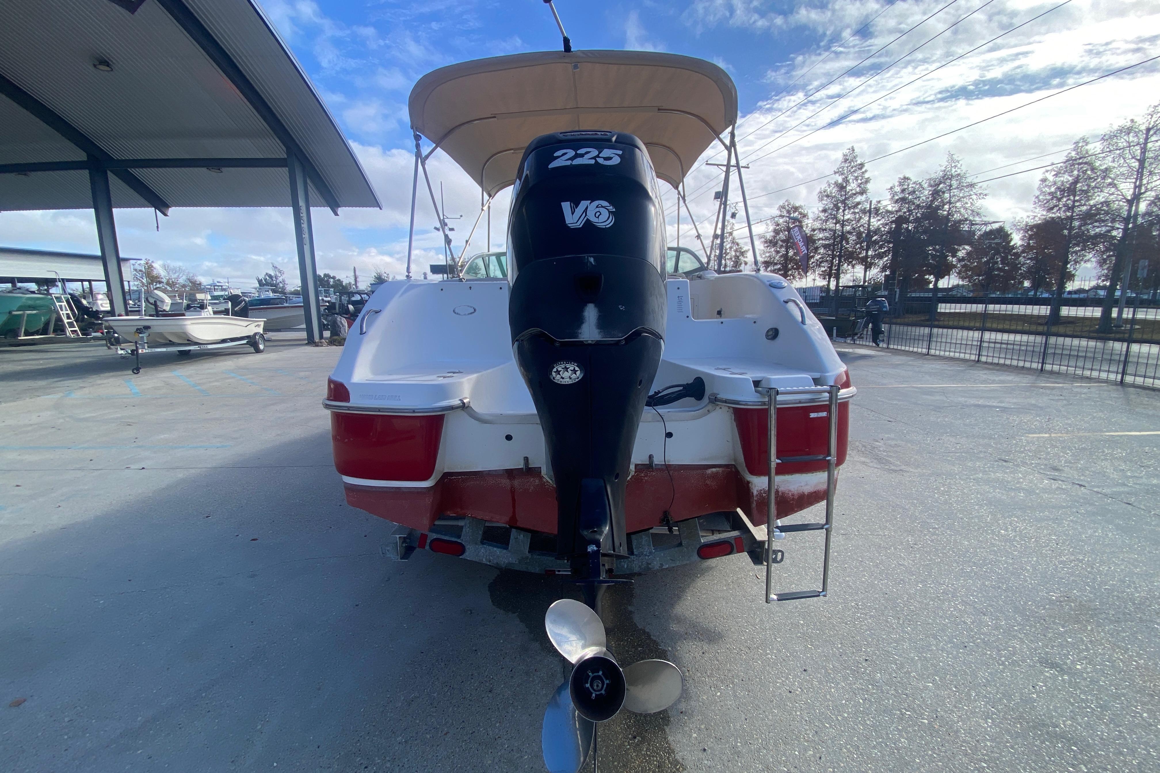 2007 NauticStar 230DC Sport Deck boat with V6 engine, parked outdoors.