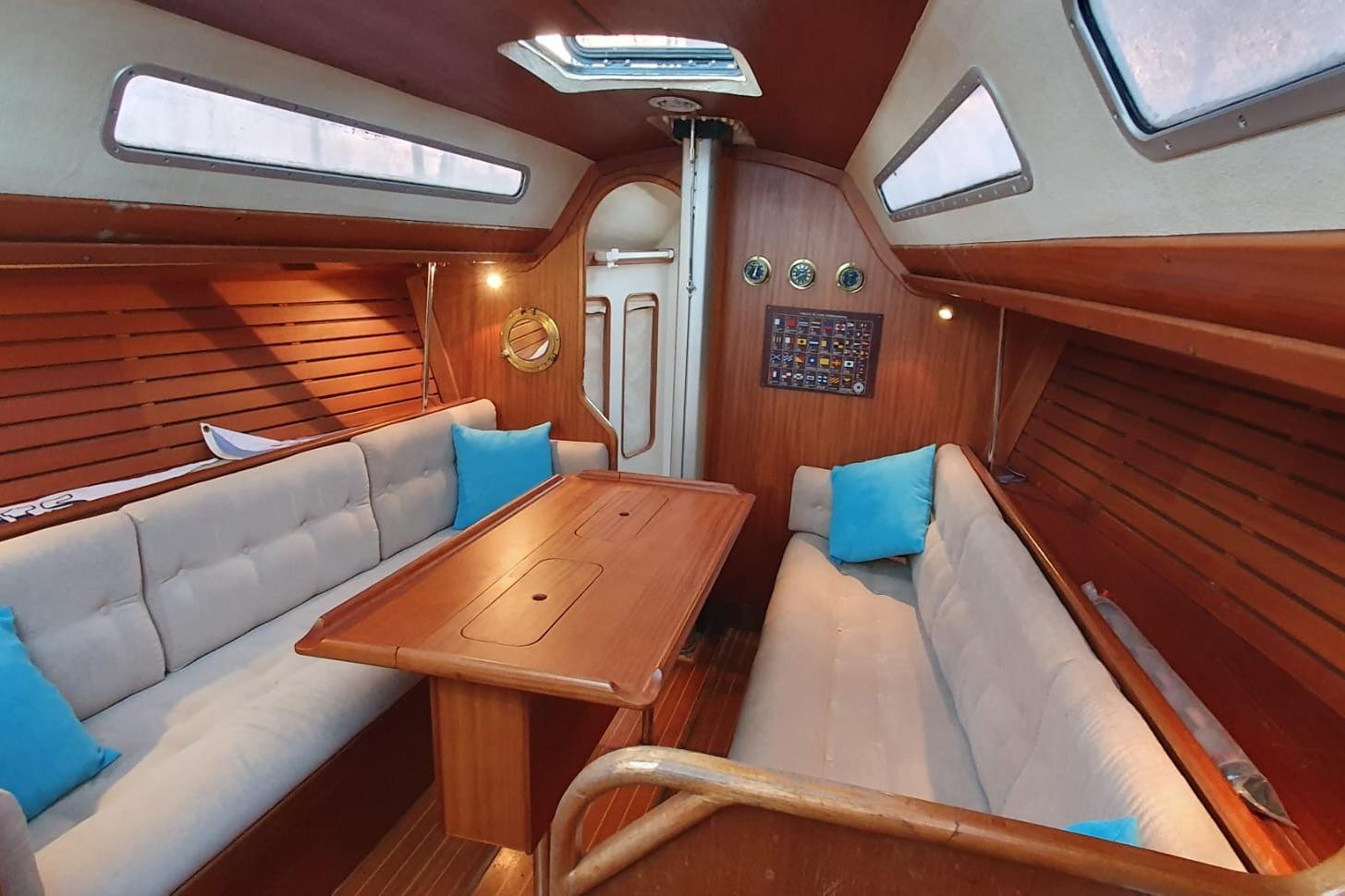 Interior of 1989 X-Yachts X-119 sailboat with wooden finish and cozy seating area.
