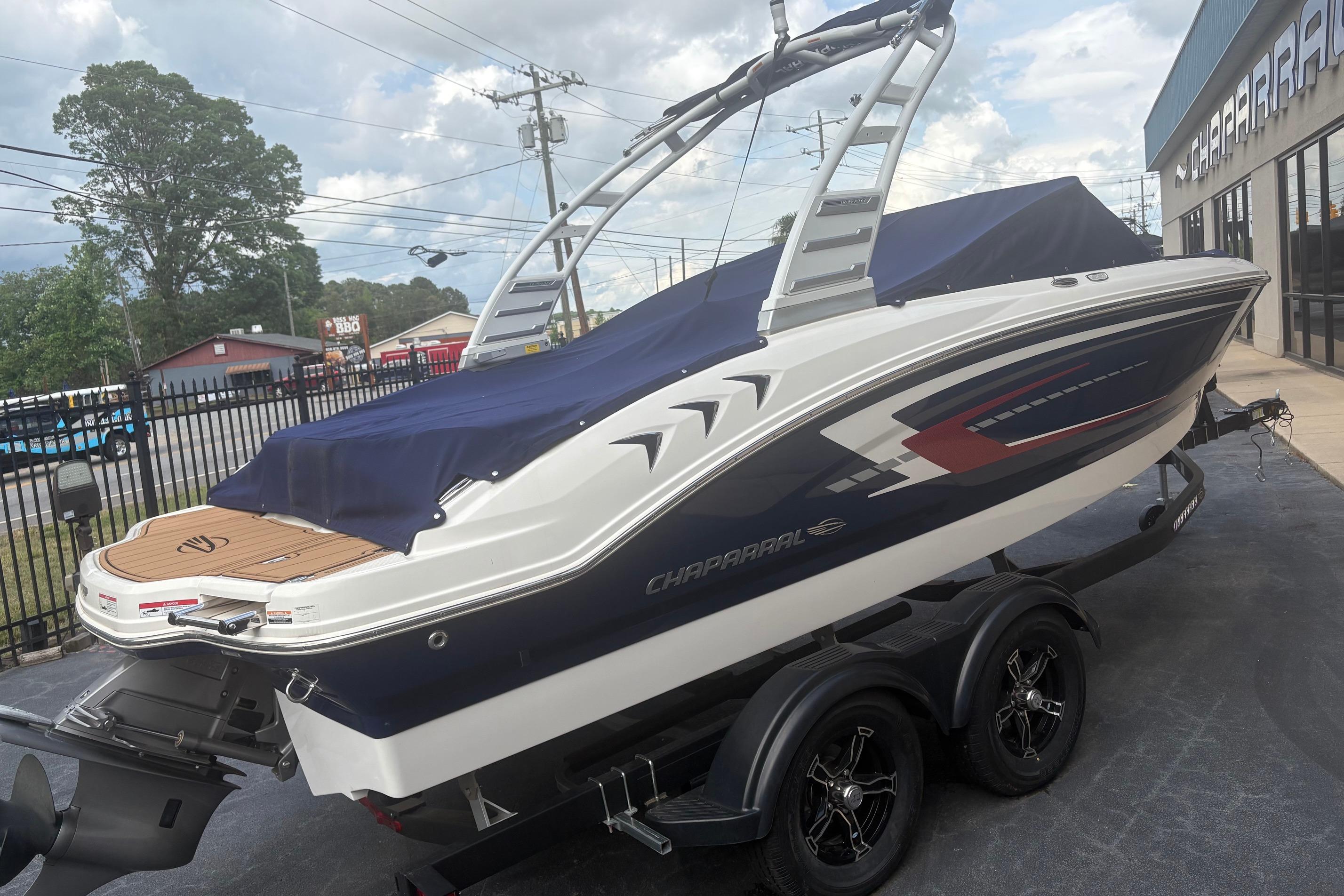 2025 Chaparral 21 SSi boat on trailer, covered and parked outdoors.
