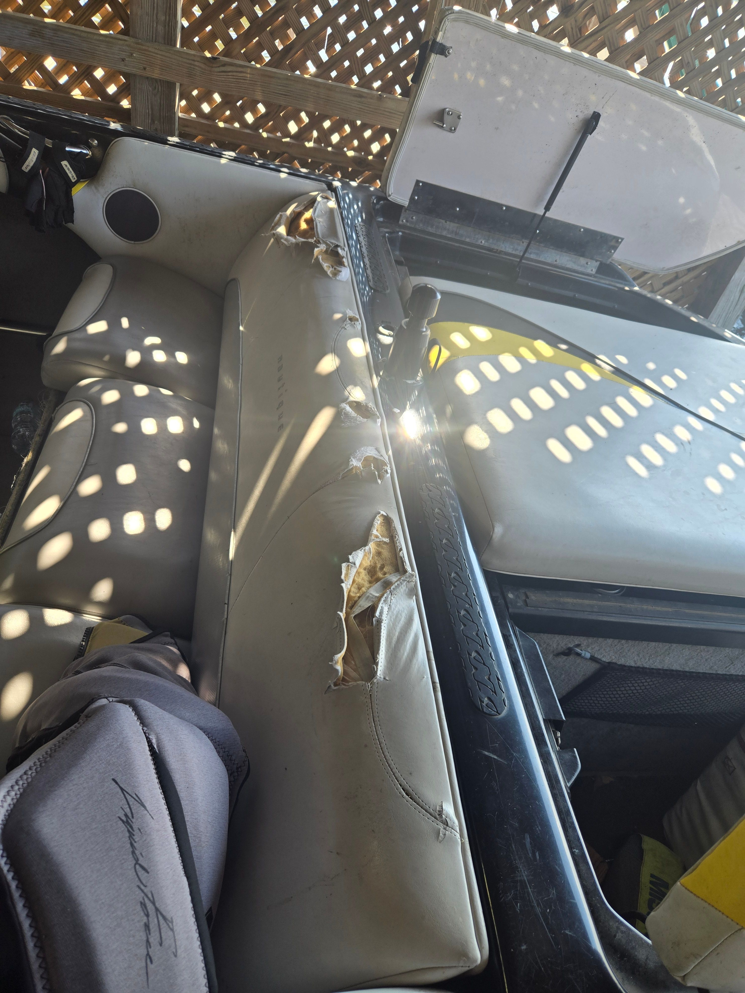 The image shows the worn interior of a 2003 Correct Craft Air Nautique with damaged seats.