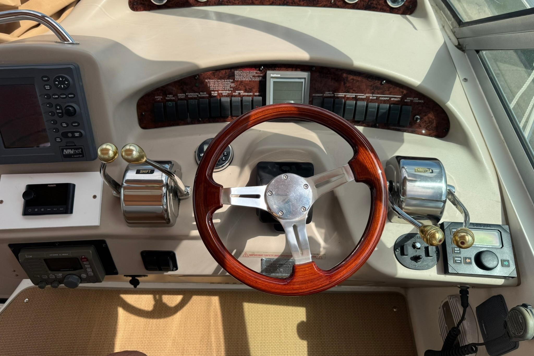 2001 Sea Ray 340 Sundancer helm with wooden steering wheel and control panel.