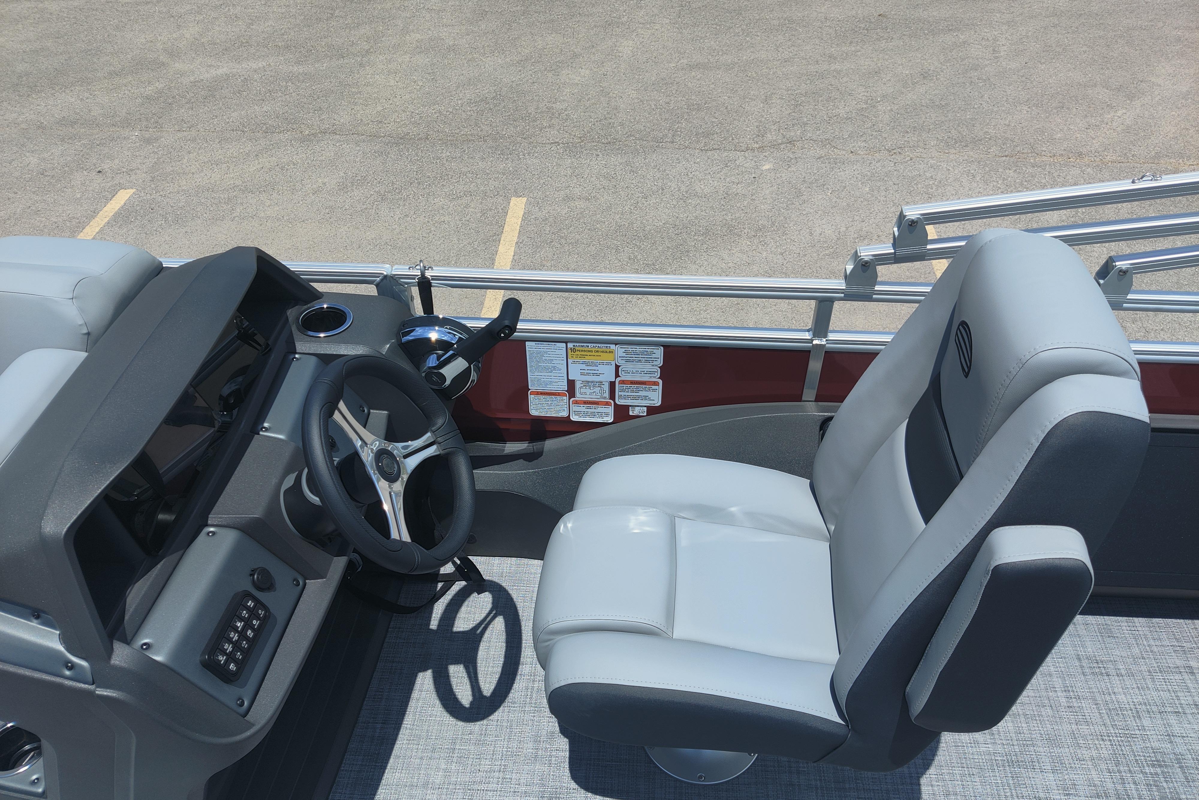 2026 Sun Tracker SportFish 22 DLX boat interior with steering wheel and captain's chair.