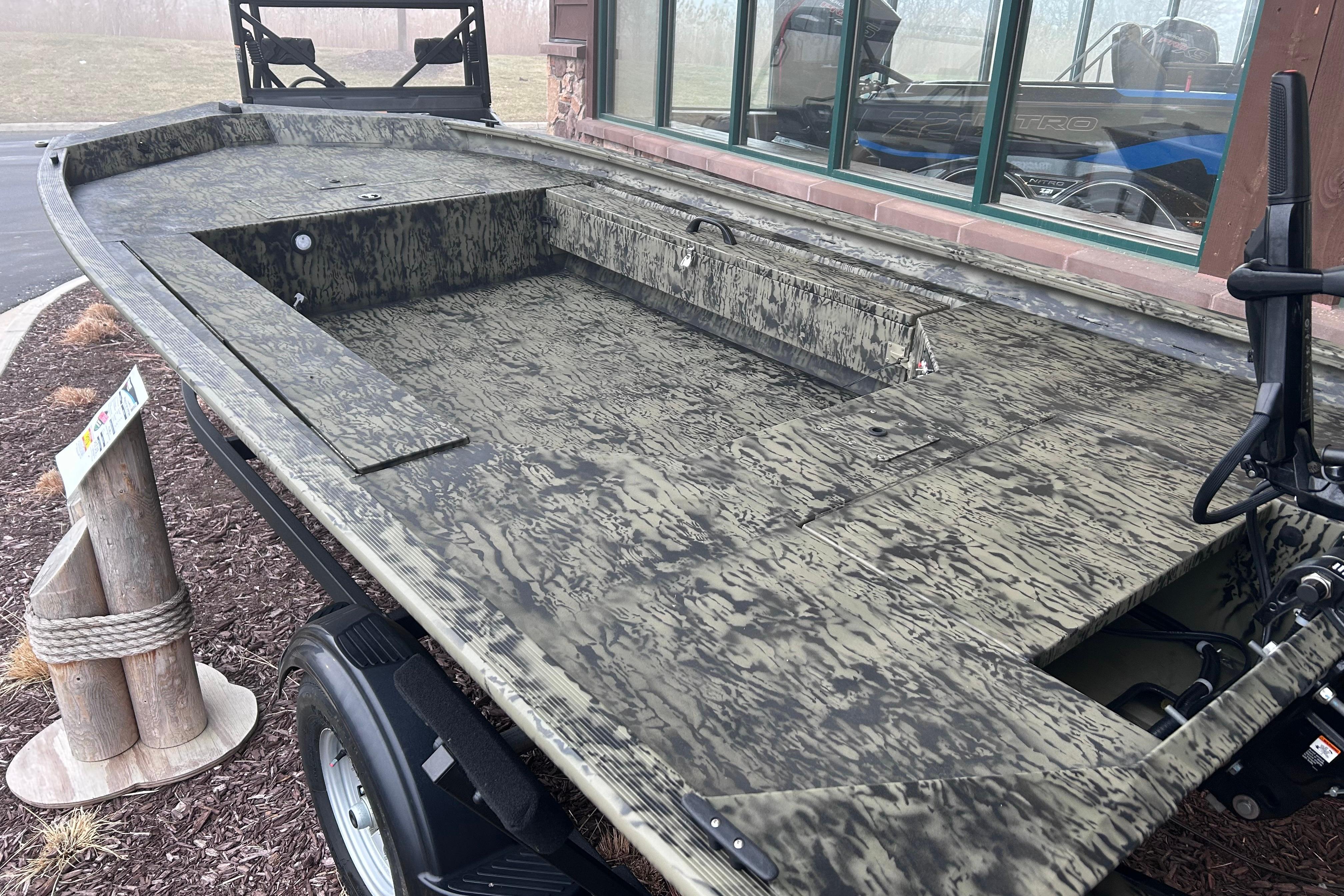 2026 Tracker Grizzly 1654 T Sportsman boat with camouflage design, displayed outdoors.