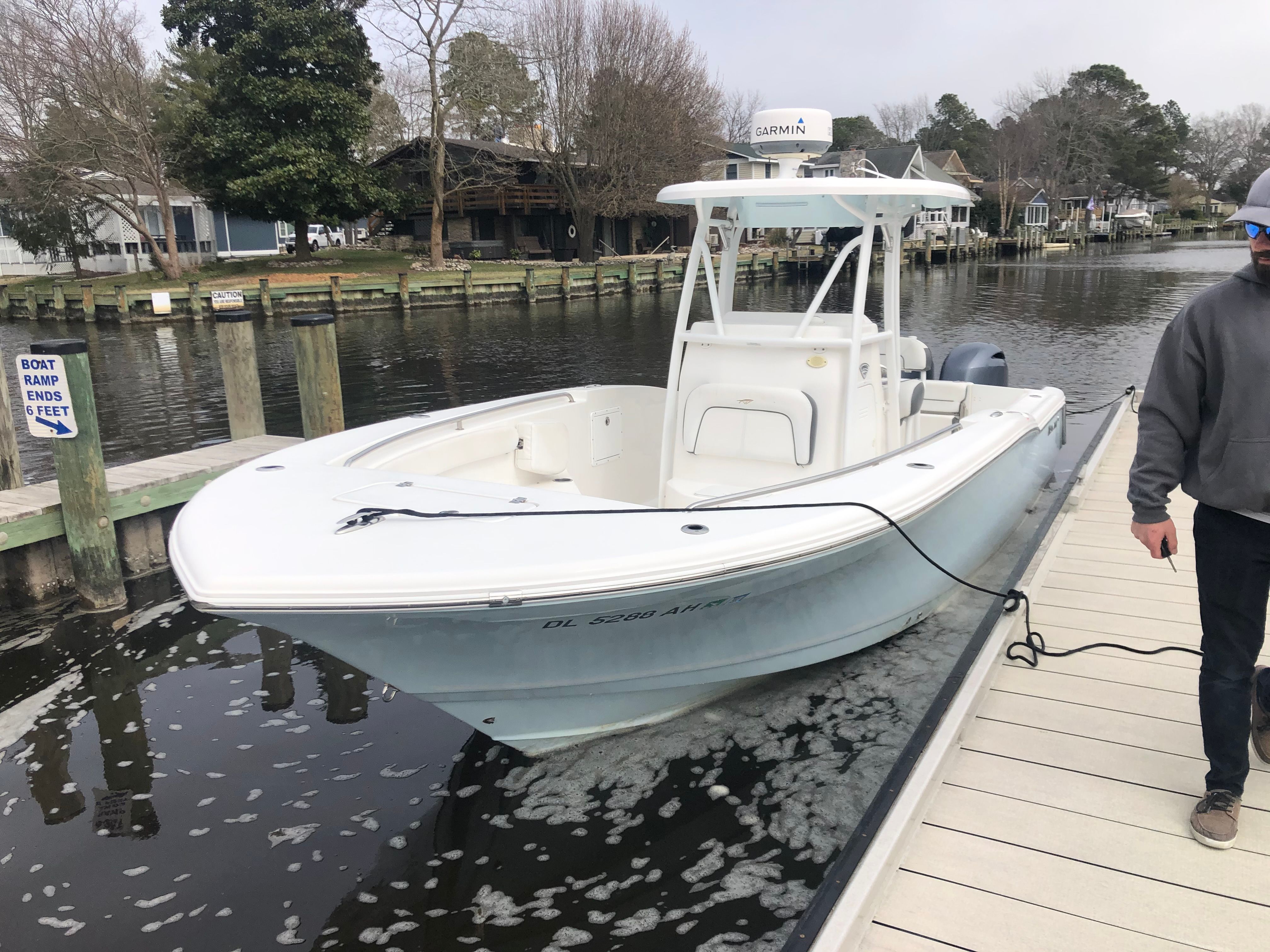 A white boat docked in a calm canal setting.