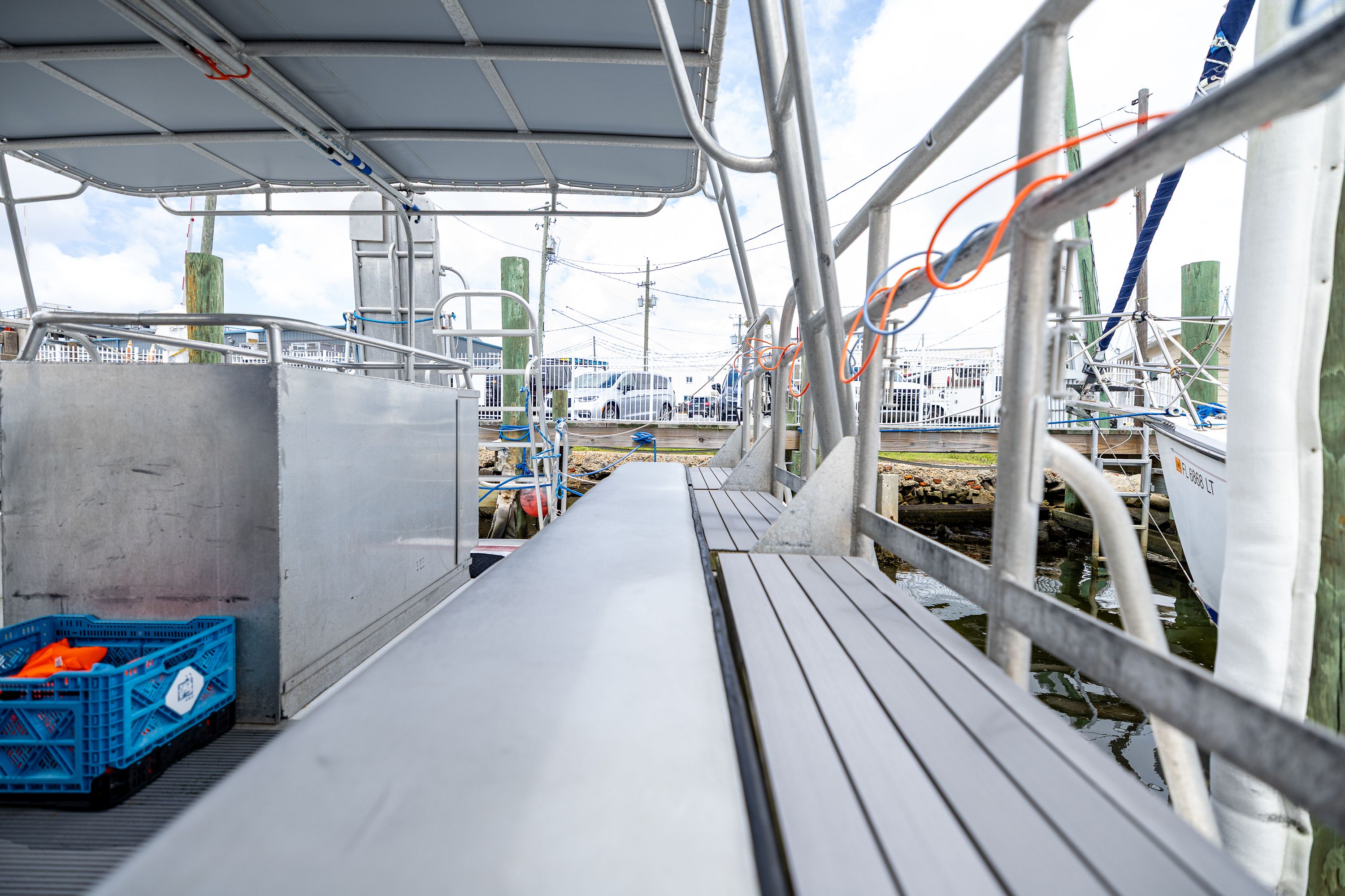 The image shows the deck of a dive boat with benches and railings, docked at a pier.
