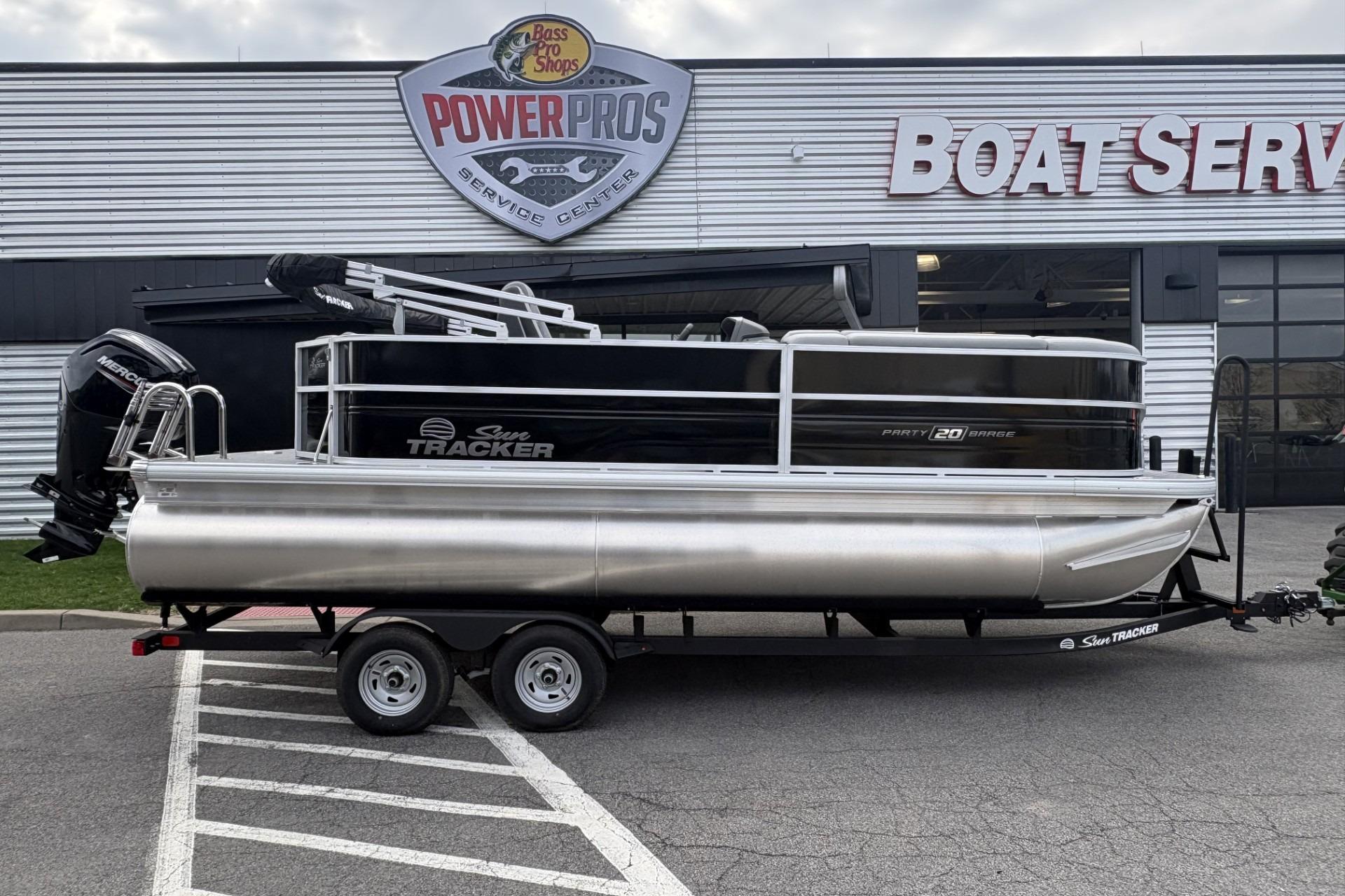 2026 Sun Tracker Party Barge 20 DLX pontoon boat on trailer at service center.