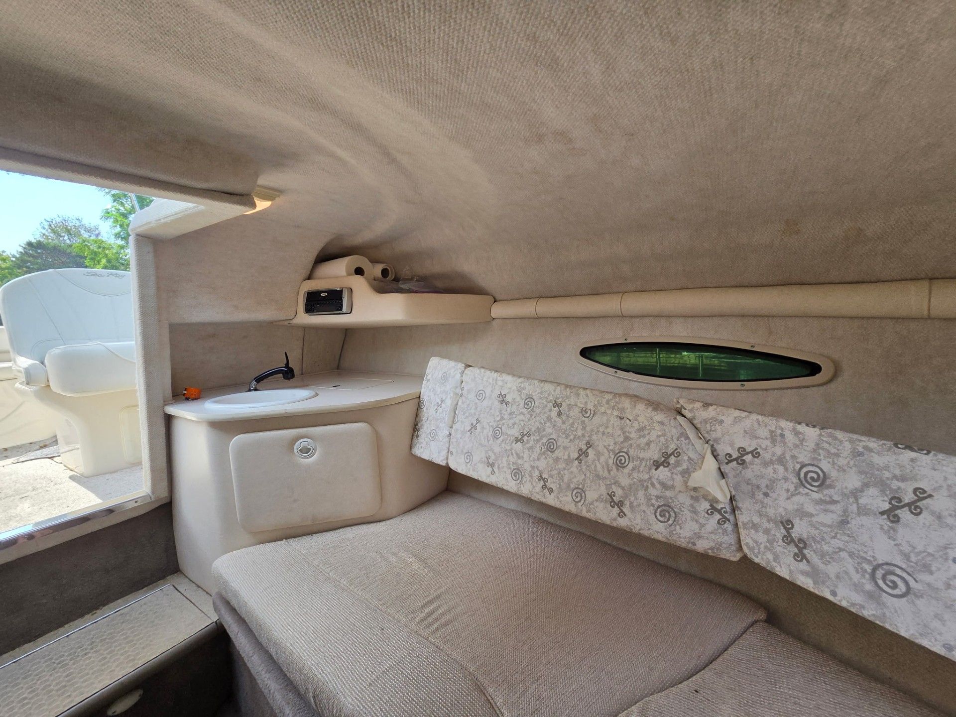Interior of a 2002 Sea Ray 225 Weekender with seating area and sink.