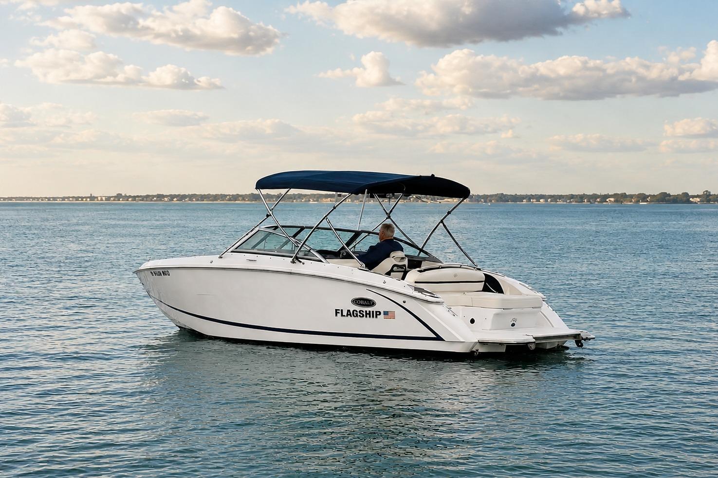 2019 Cobalt R3 boat cruising on a calm lake under a partly cloudy sky.