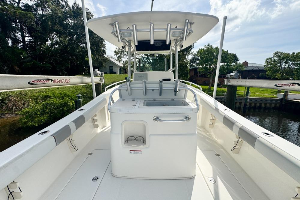 2018 Mako 284 Center Console boat docked near lush greenery.