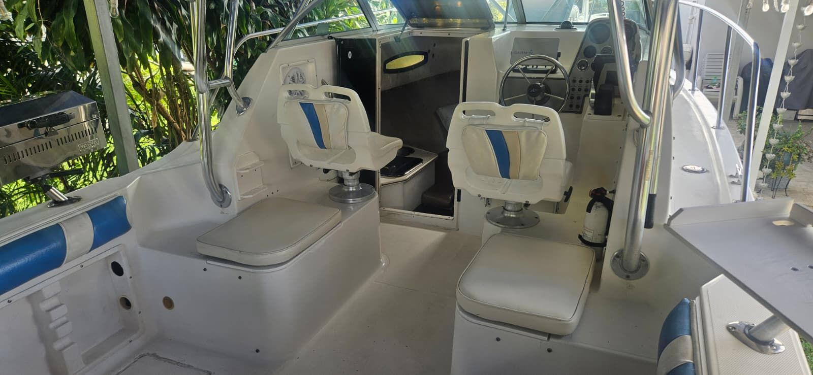 Interior of a 2000 Wellcraft 24 Walkaround boat with blue and white seating.