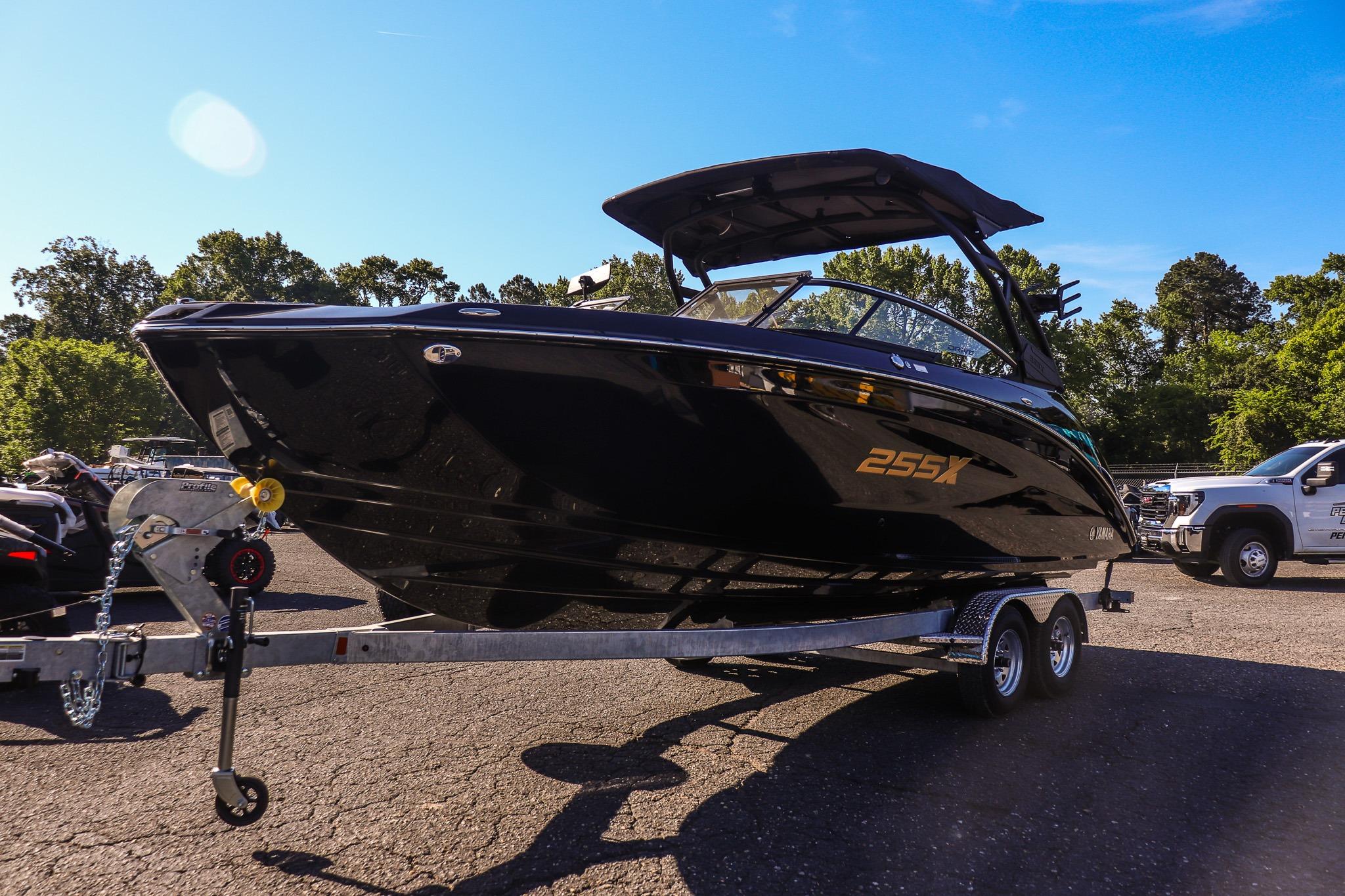 2026 Yamaha Boats 255XD on trailer, sleek black design under clear blue sky.