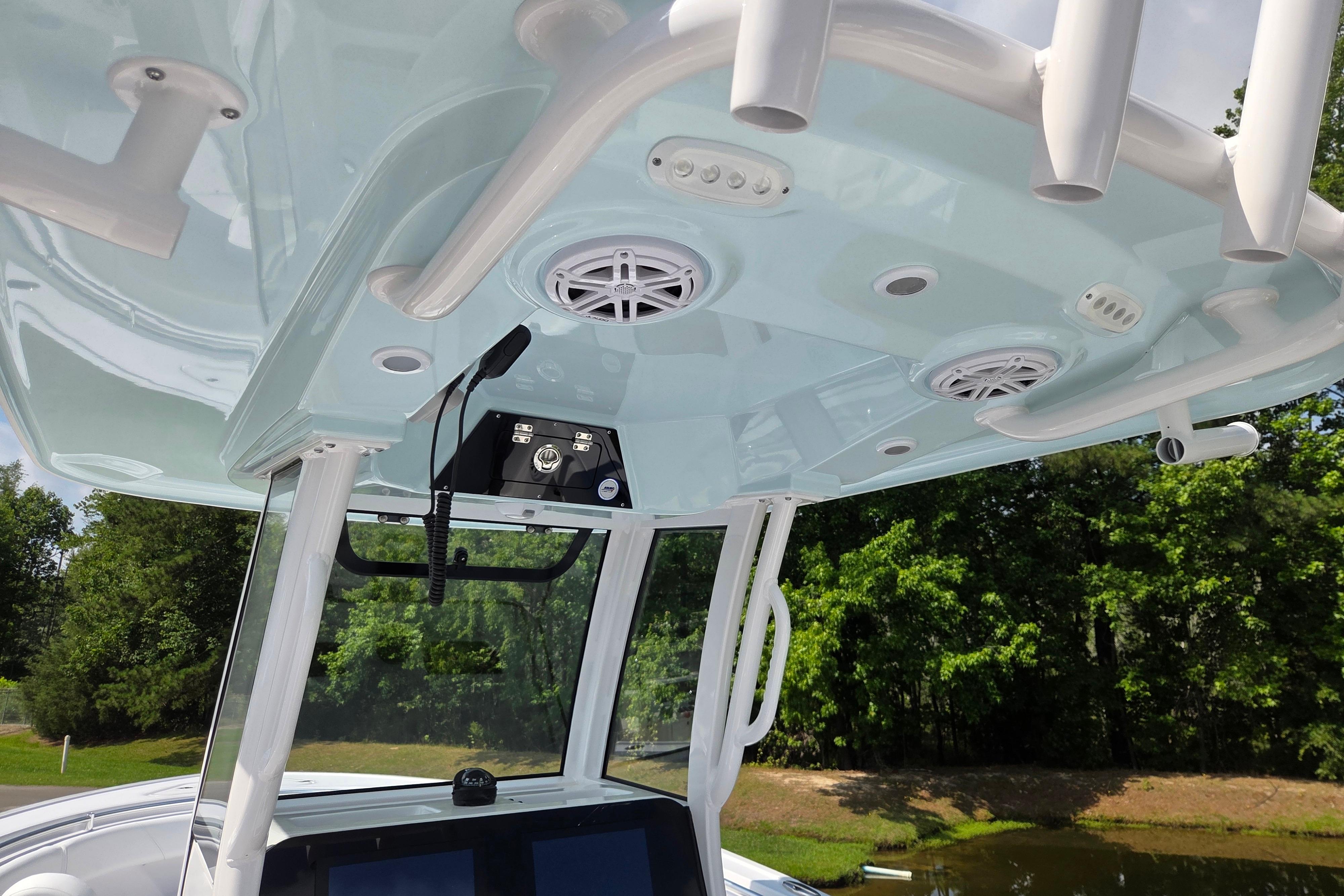 2026 Sportsman Open 252 Center Console boat interior with speakers and rod holders.