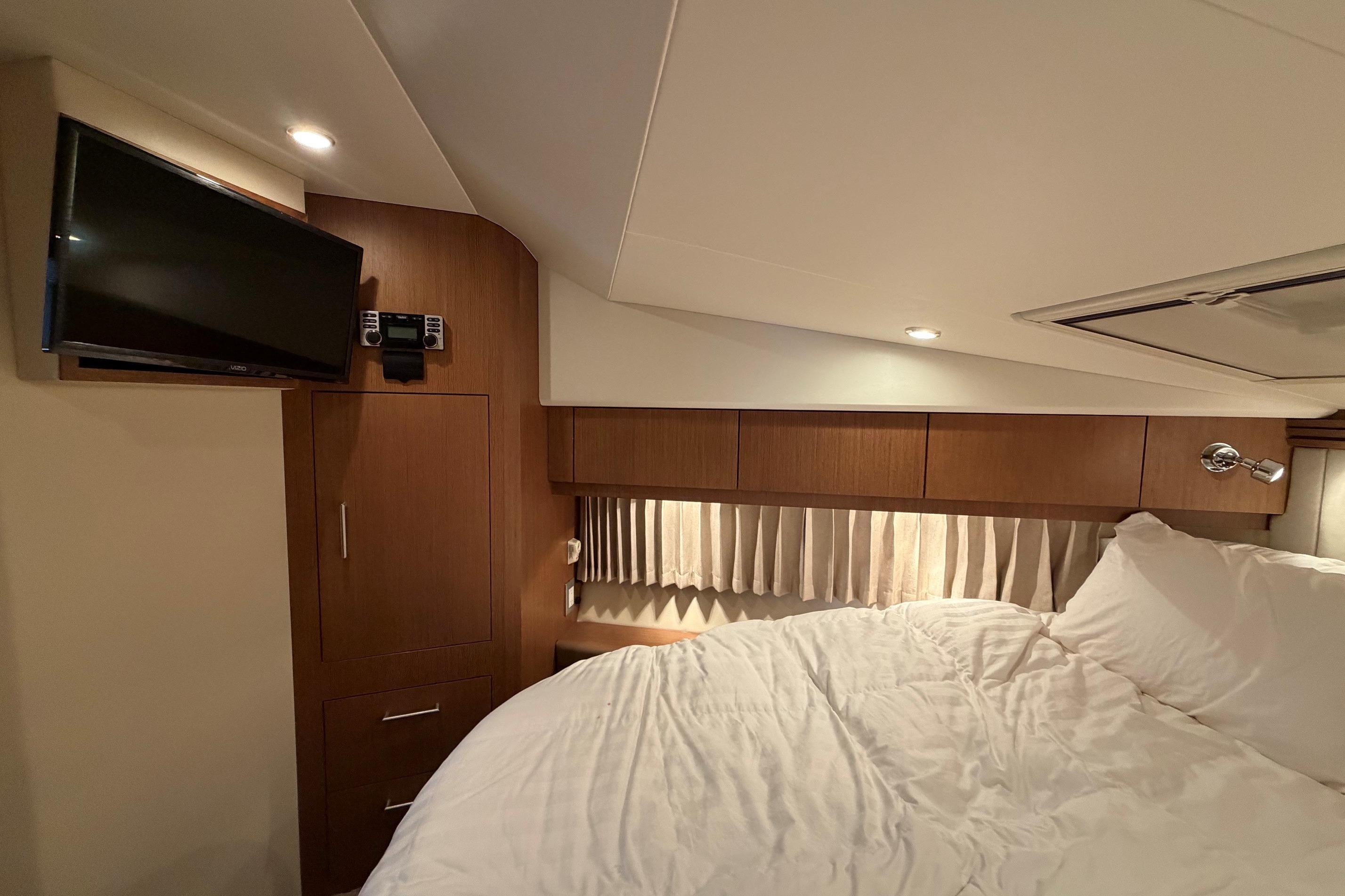 Interior cabin of 2011 Carver 44 Sojourn yacht with bed and TV.