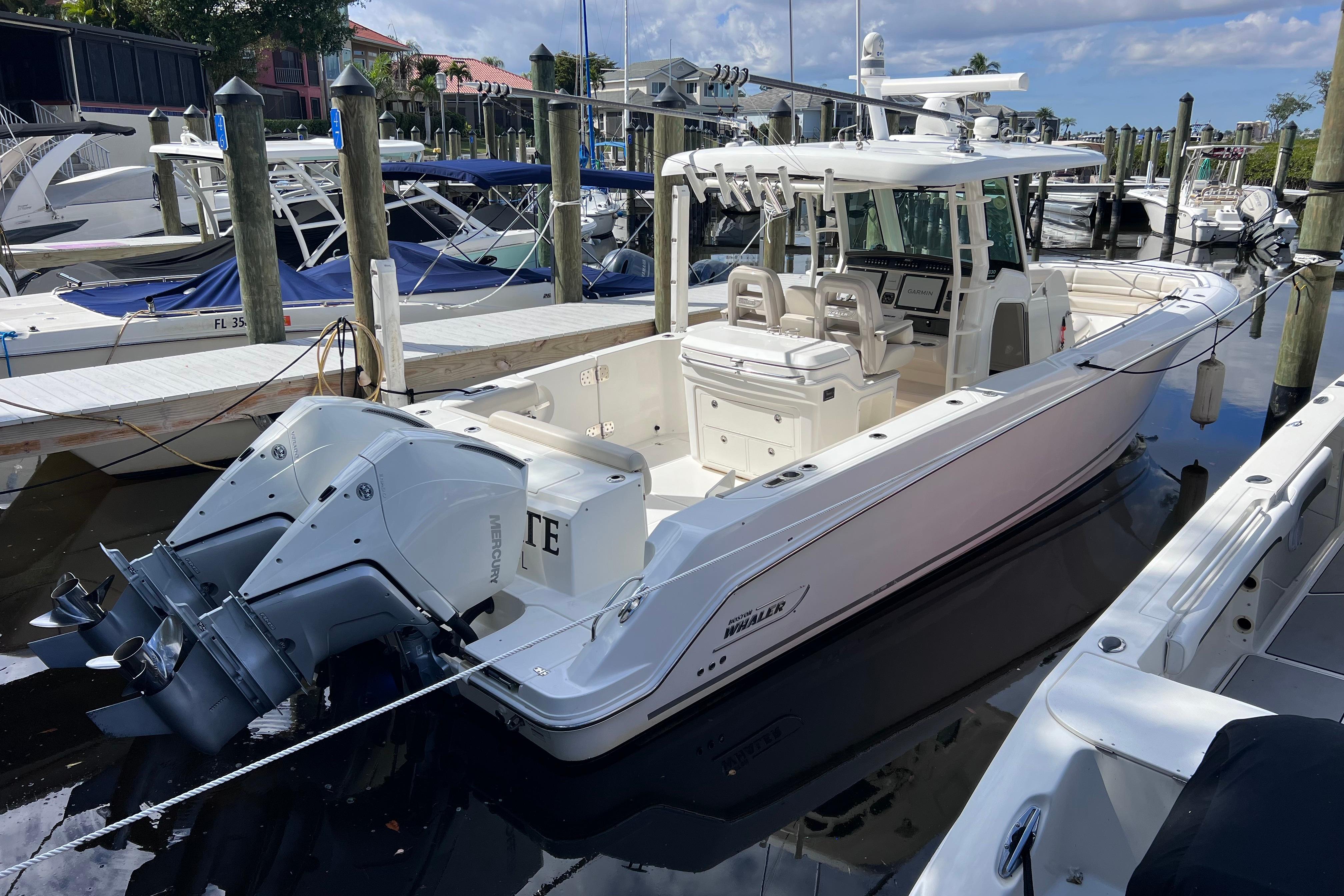2021 Boston Whaler 330 Outrage docked, featuring dual Mercury outboard engines.