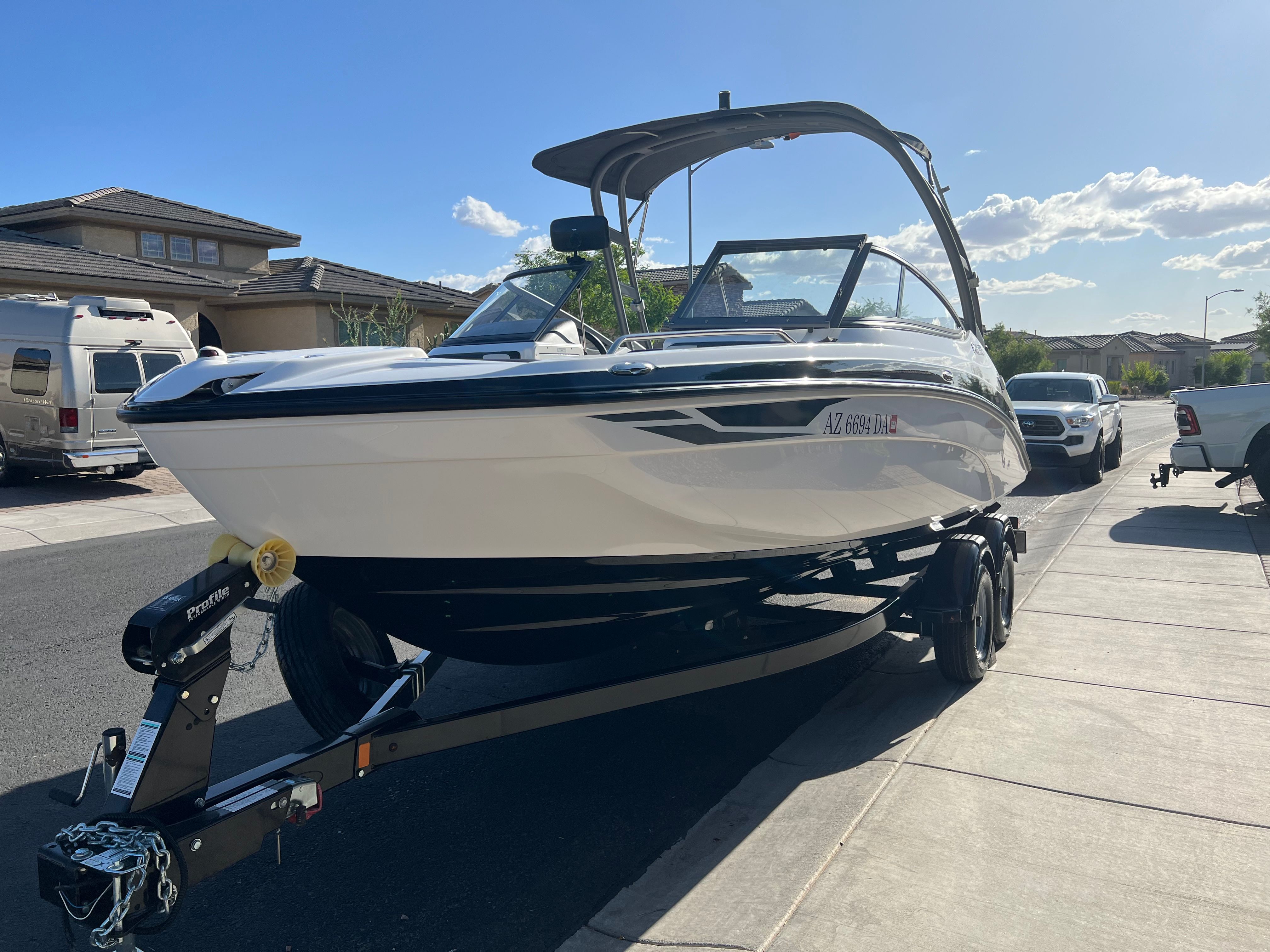A 2018 Yamaha AR210 boat on a trailer in a residential area.