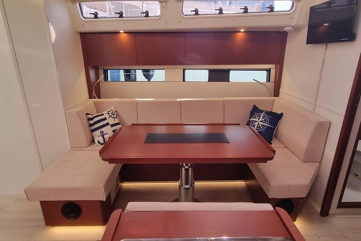 2024 Hanse 460 yacht interior with elegant seating and nautical-themed cushions.
