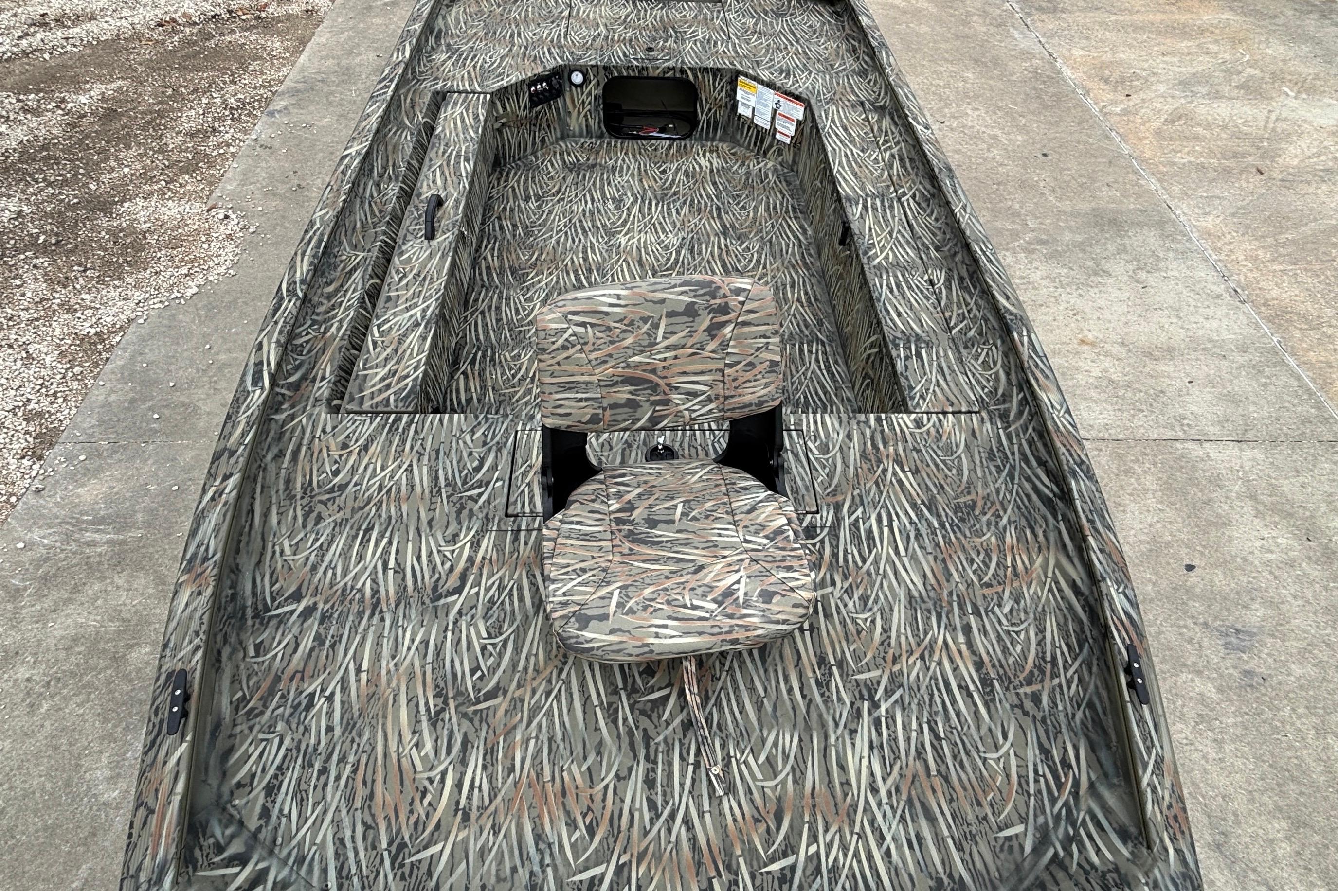 2026 Tracker Grizzly 1654 T Sportsman boat with camouflage design on concrete surface.