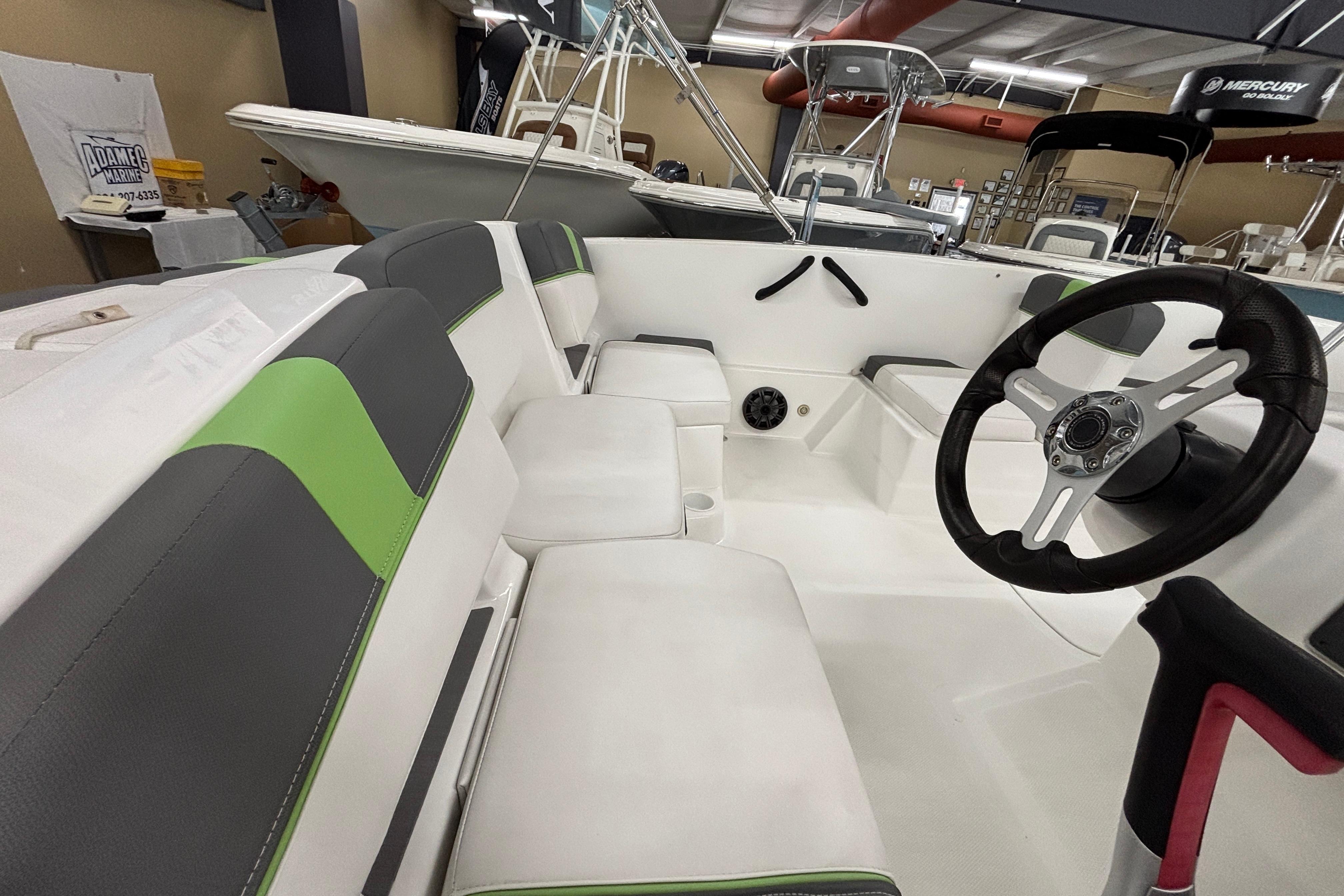 2024 Tahoe T18 boat interior with modern seating and steering wheel in showroom.