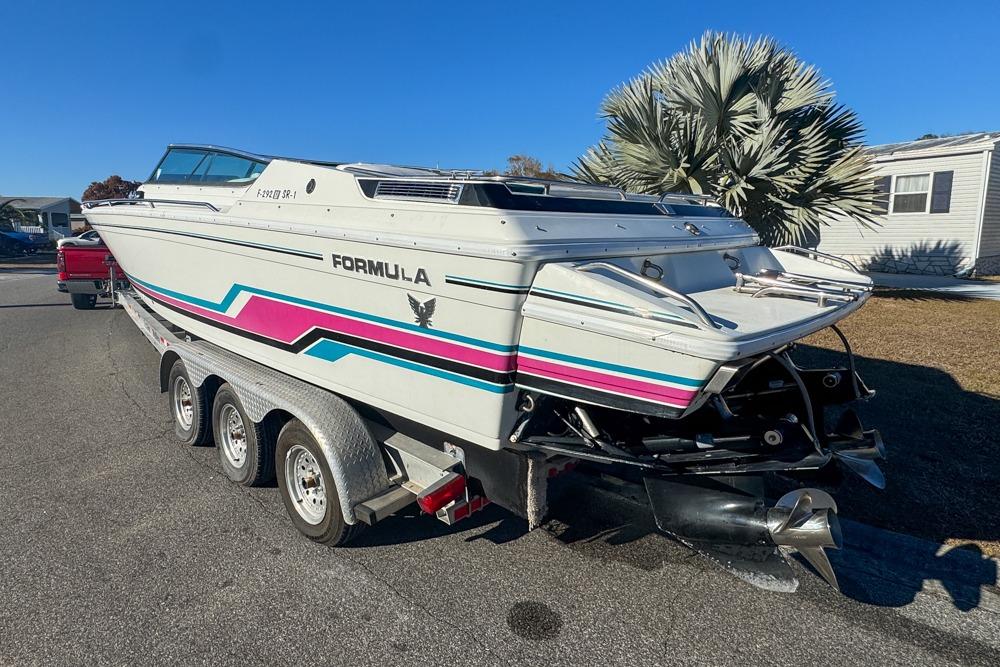 1989 Formula 292 SR-1 speedboat on trailer, featuring vibrant stripes and sleek design.
