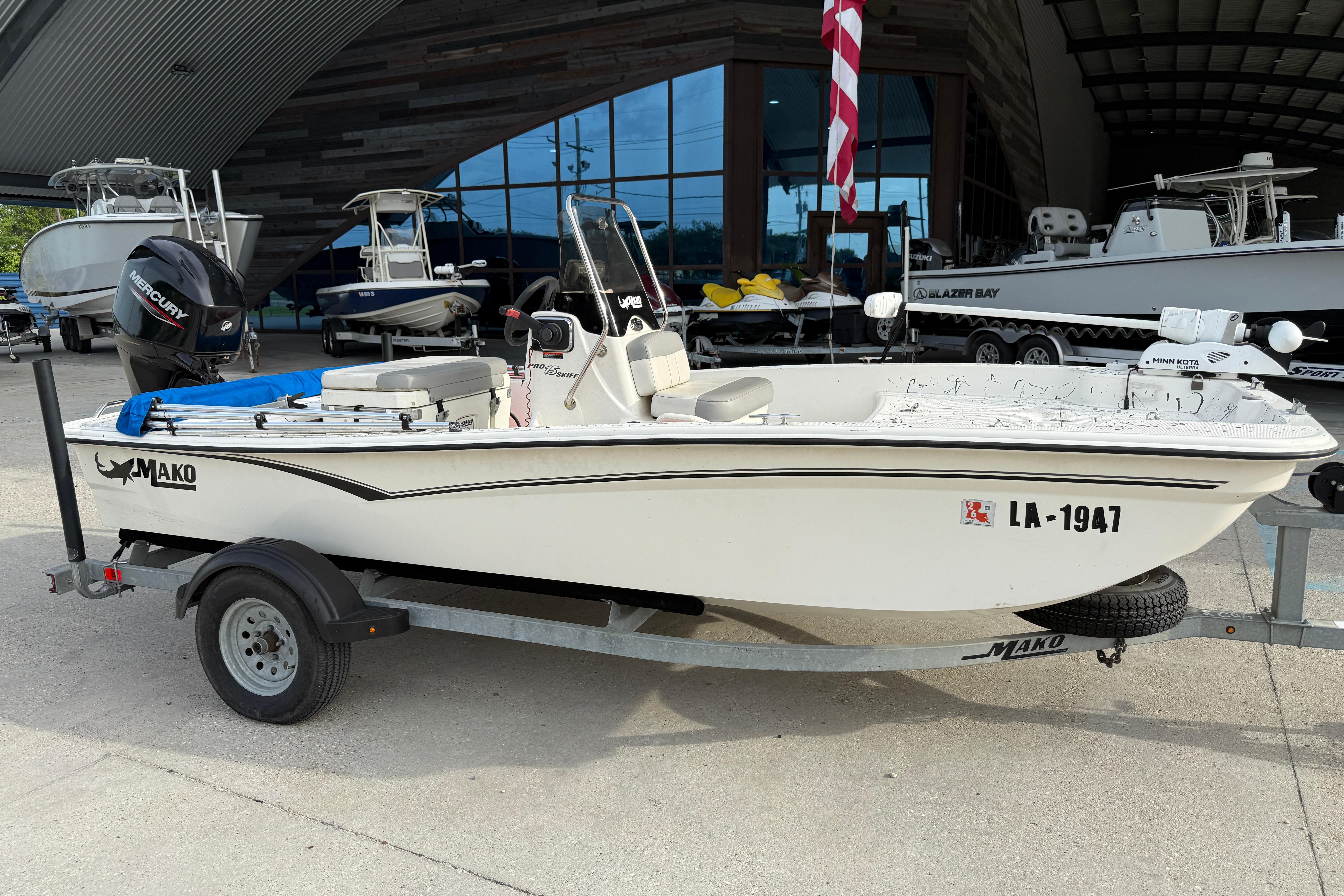 2020 Mako Pro Skiff 15 CC boat on trailer, parked outside a showroom.