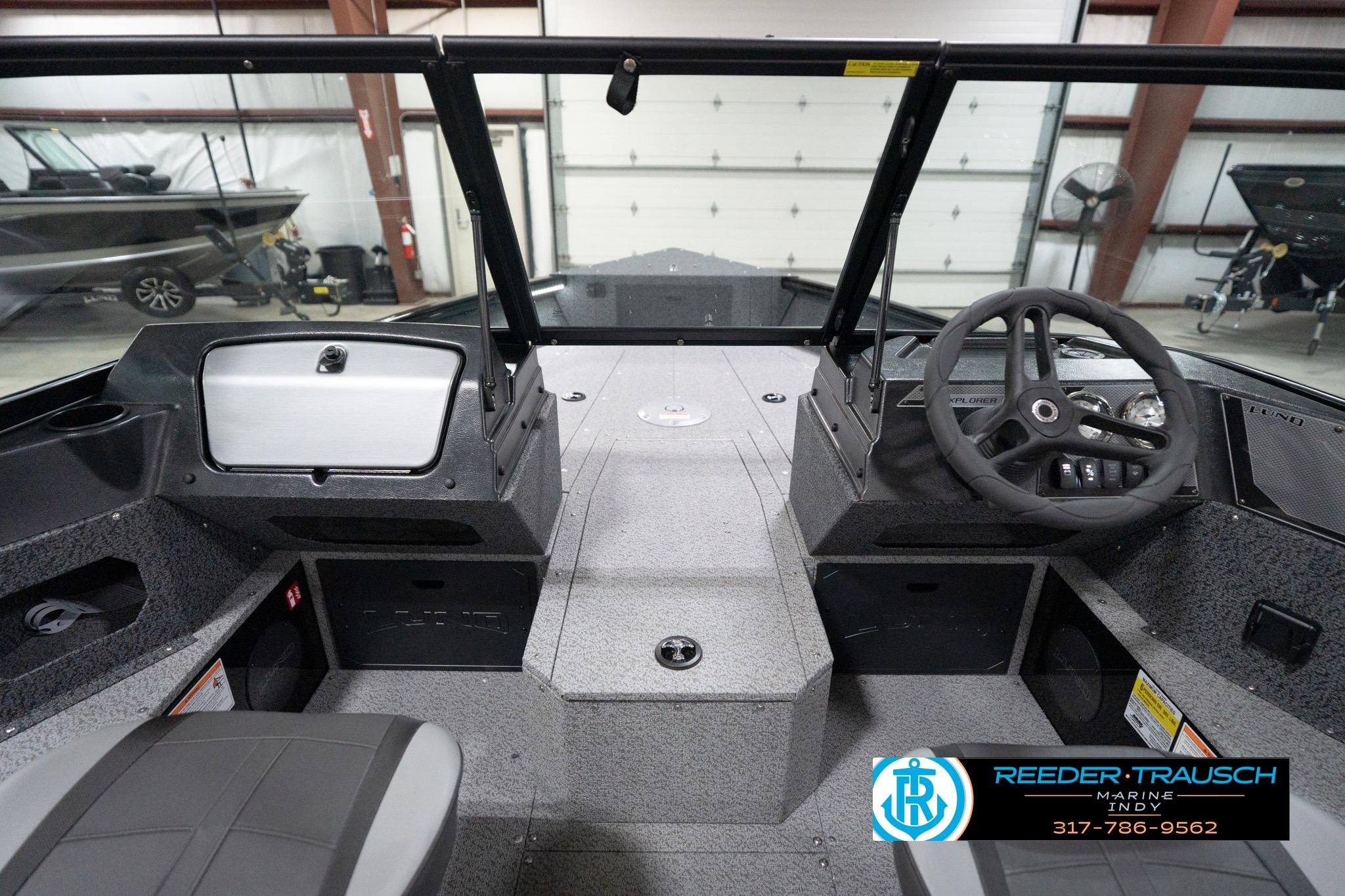 2026 Lund 1800 Explorer Sport boat interior with steering wheel and dashboard in showroom.