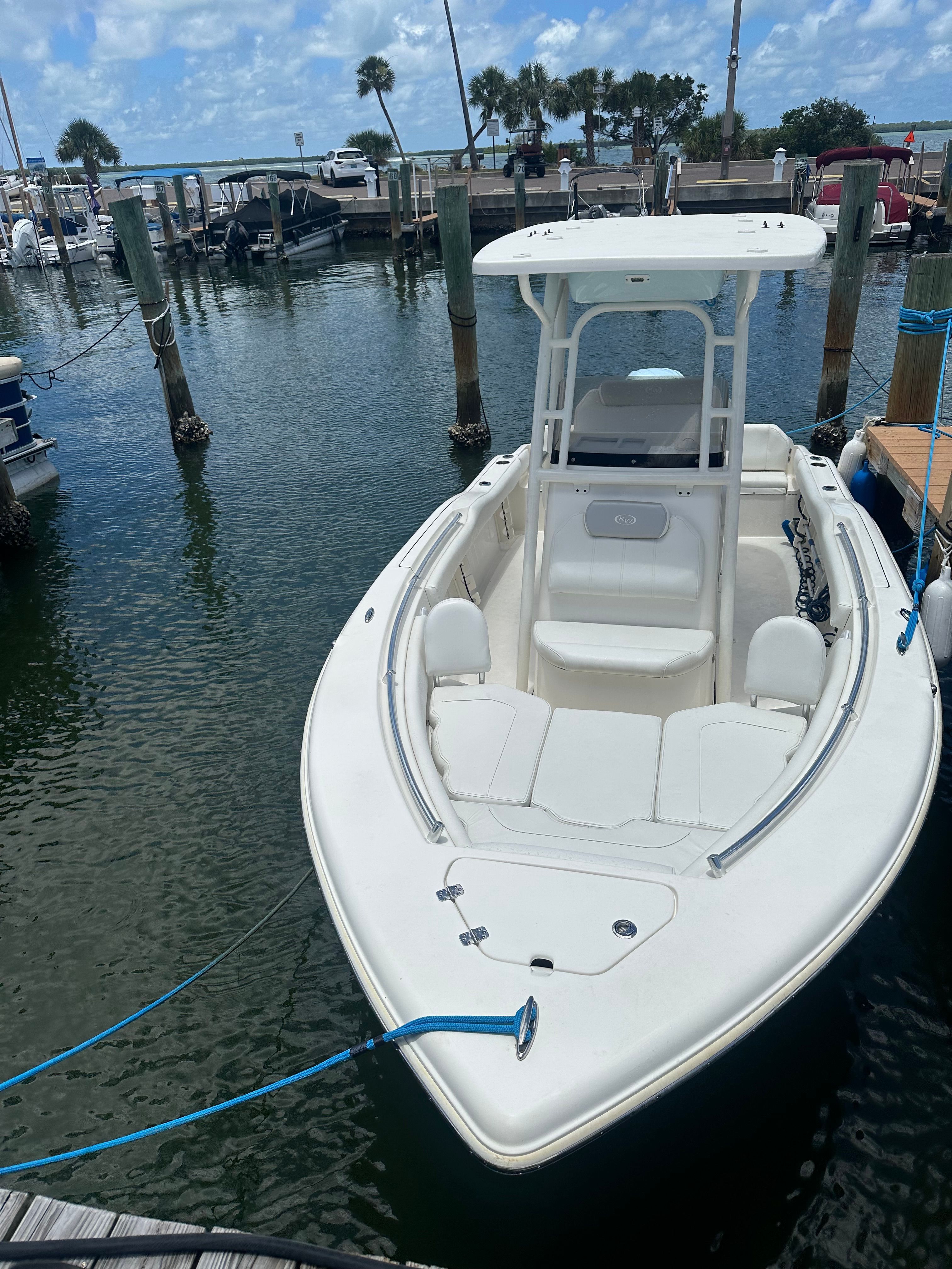 A white boat is docked in a calm harbor.