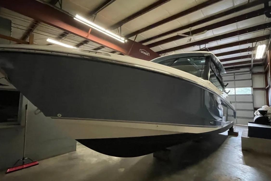 2025 Boston Whaler 330 Vantage boat in a warehouse, side view.