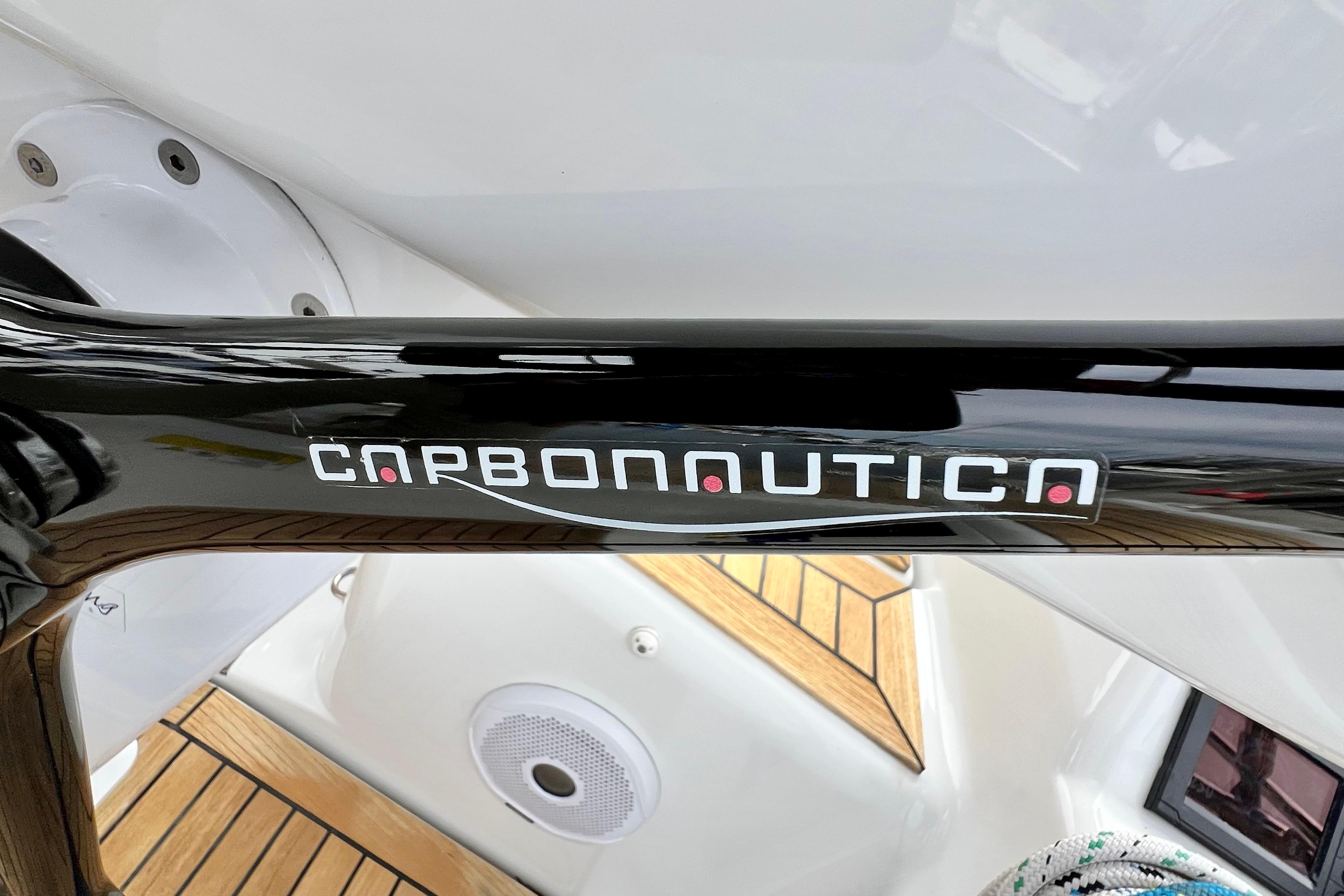 Carbonautica steering wheel on 2016 Hanse 455 yacht, featuring sleek black design and wooden deck.