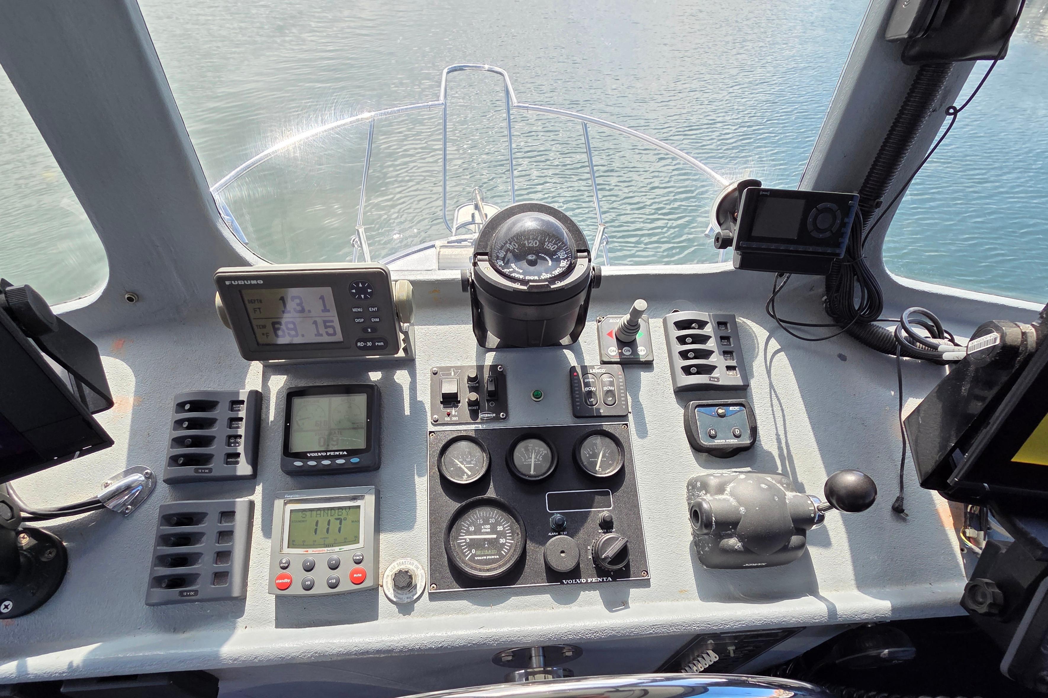 Cockpit of 1995 Custom 32 Branko Enclosed Bridge with navigation instruments and controls.