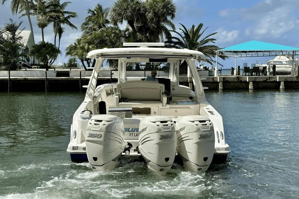 2019 Boston Whaler 350 Realm boat with triple Mercury engines in a scenic marina.