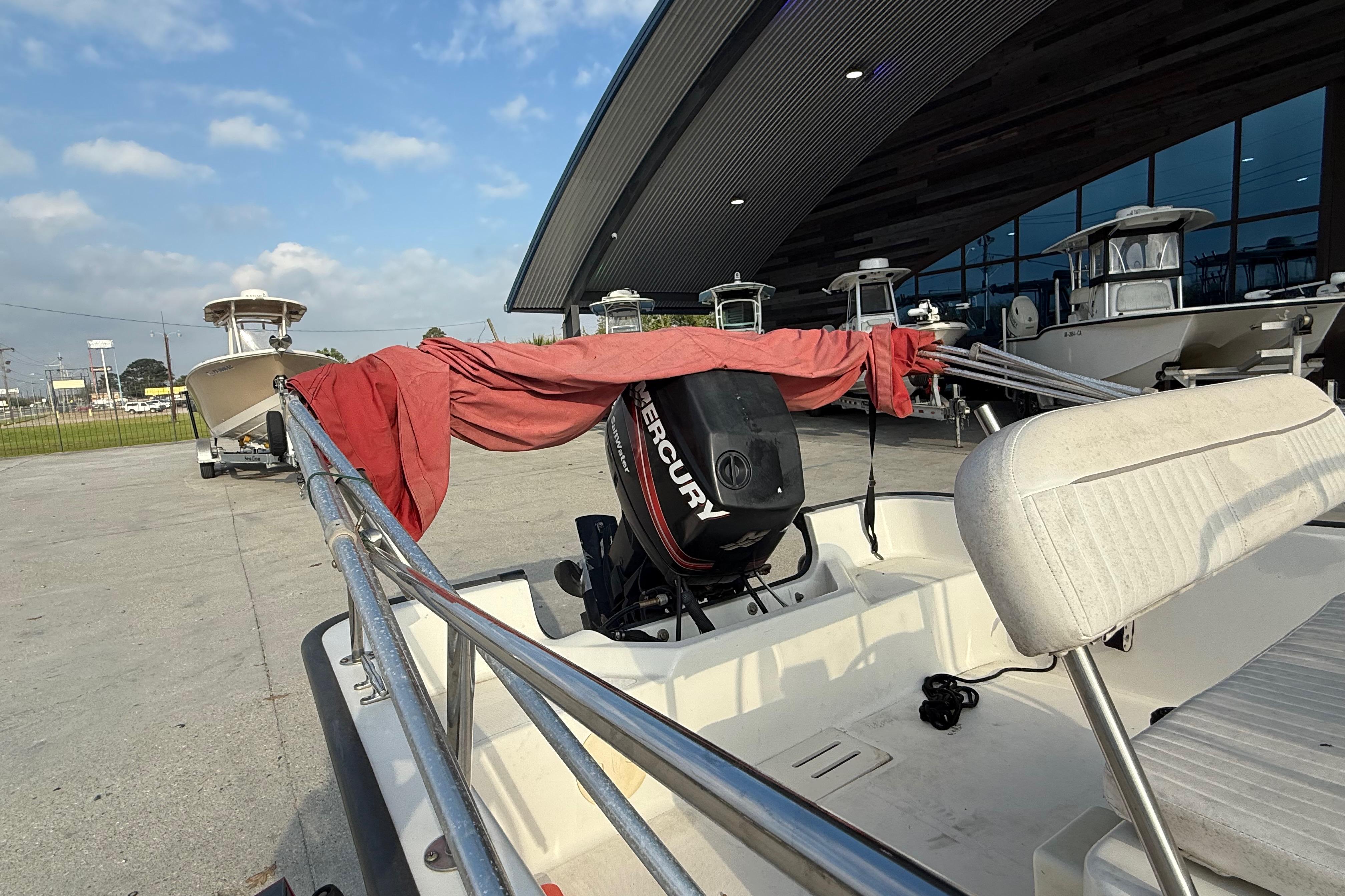 2005 Boston Whaler 17 Montauk boat with Mercury engine, docked outdoors.
