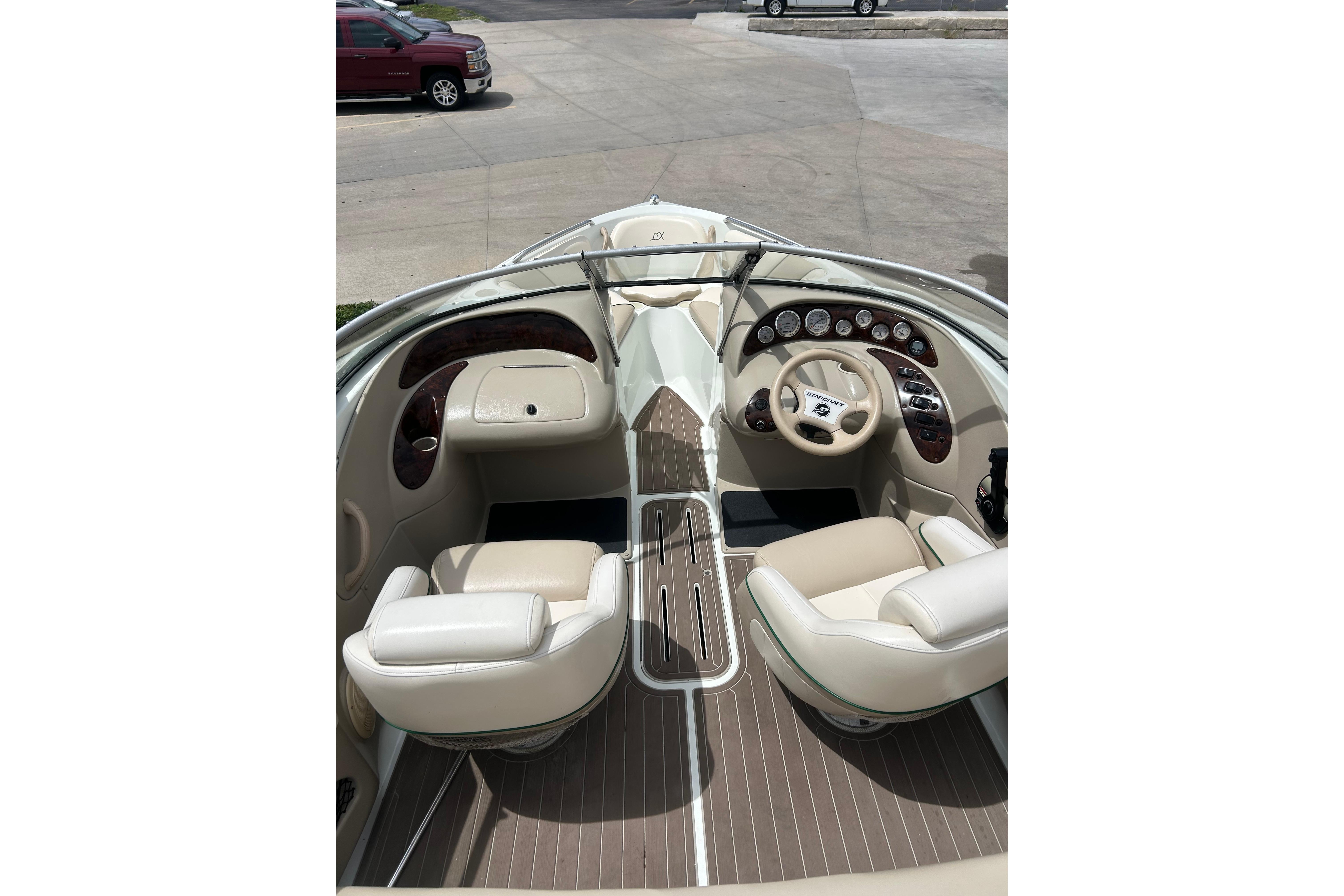 Interior of a 2000 Starcraft 1810 boat with beige seating and dashboard controls.