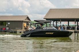 2026 Yamaha Boats 255XD cruising near a dock on a sunny day.