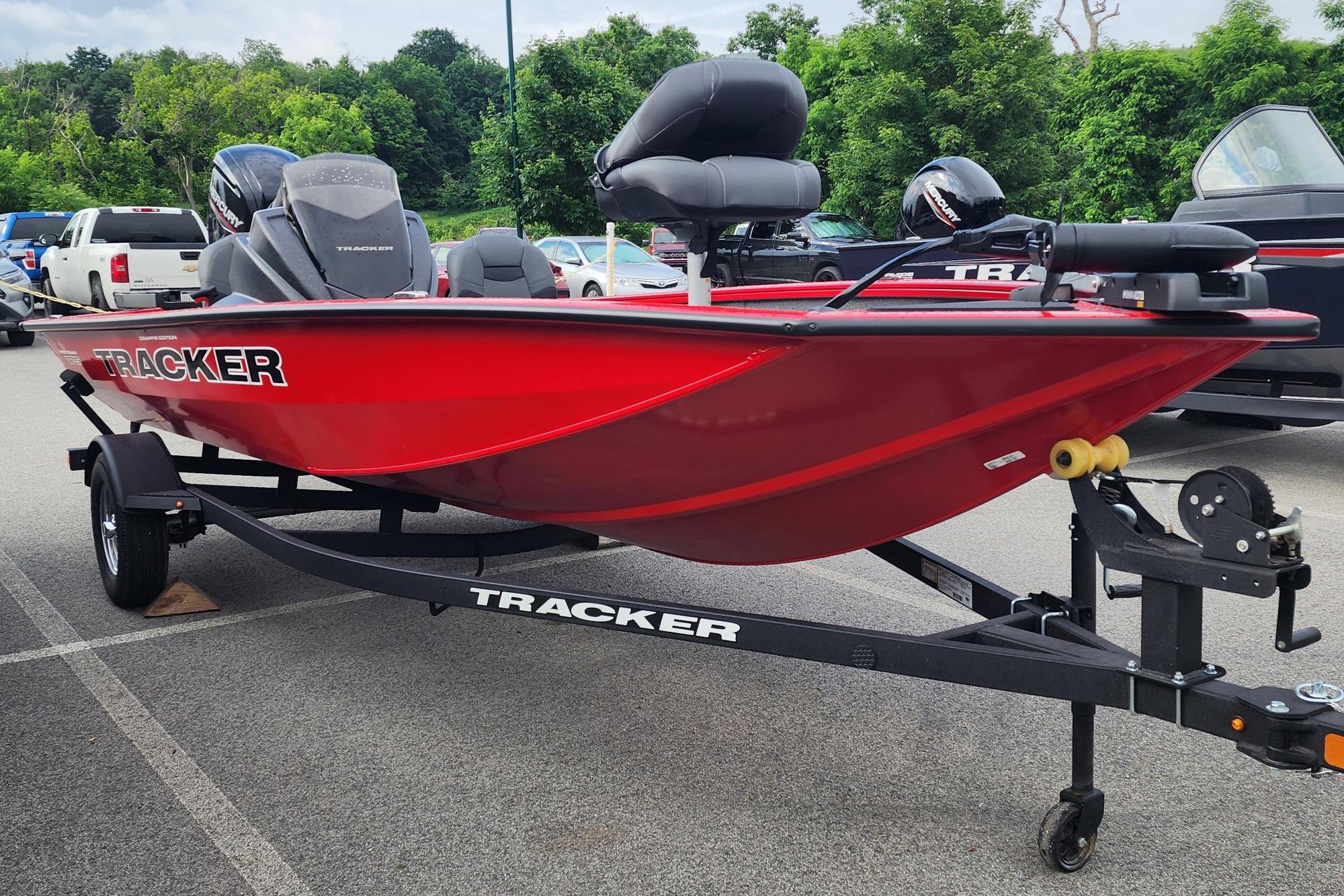 Red 2026 Tracker Pro Team 175 Crappie Edition boat on trailer in parking lot.