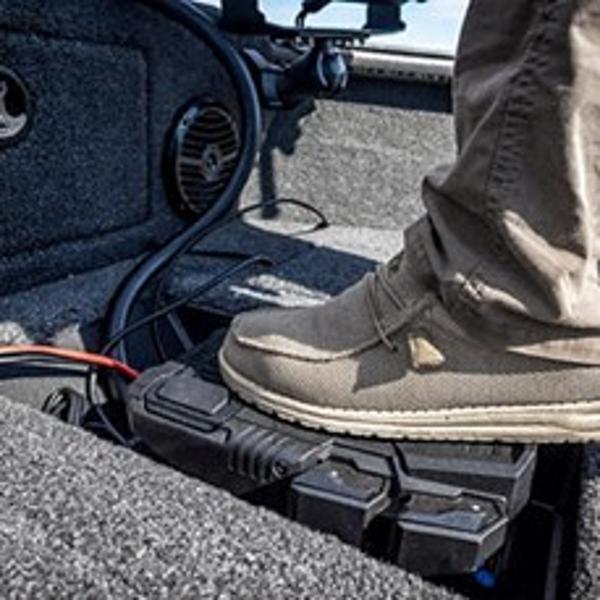 Foot on Lund 2075 IMPACT XS boat deck, showcasing interior details and equipment.