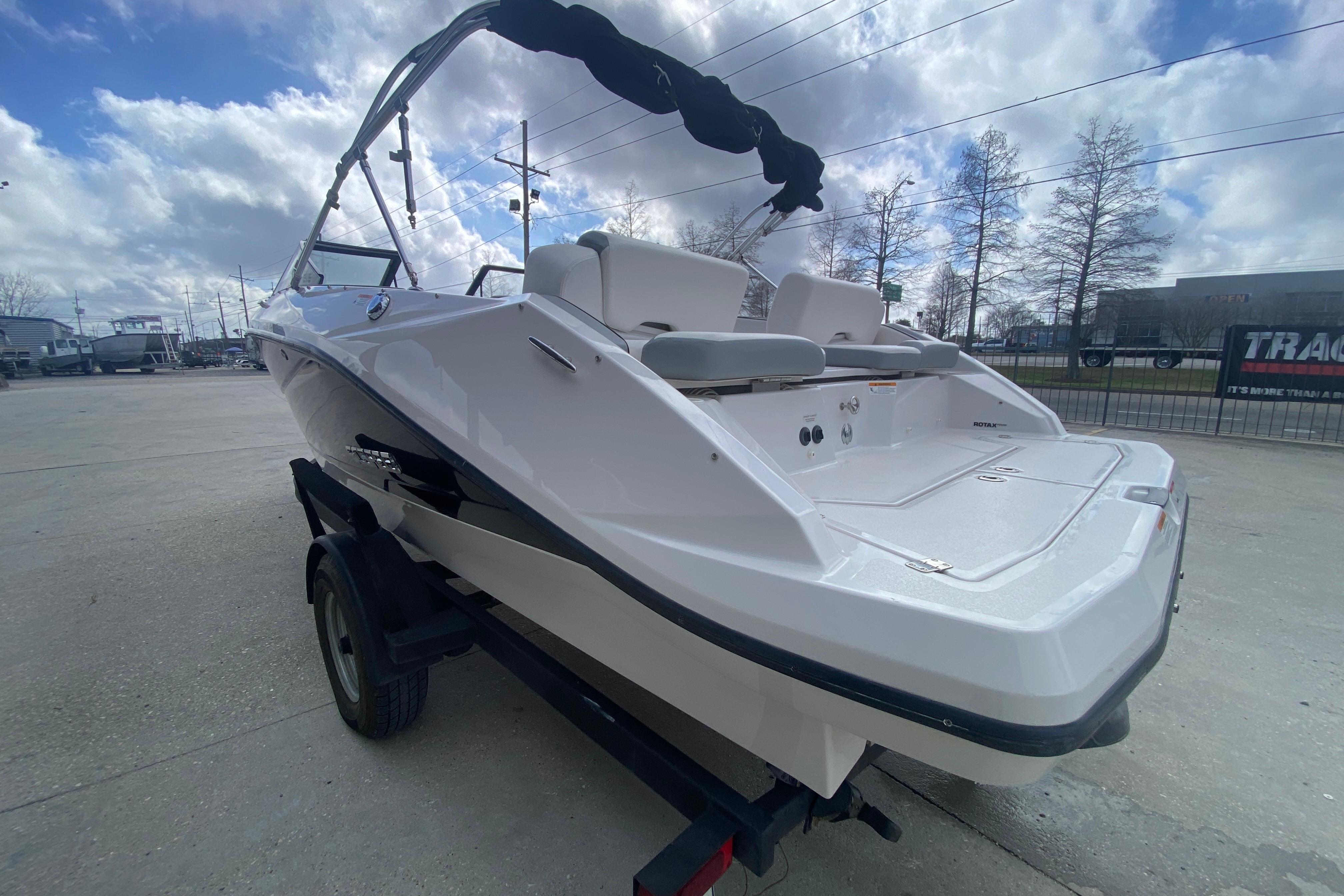 2018 Scarab 215 G boat on trailer, rear view, under cloudy sky.